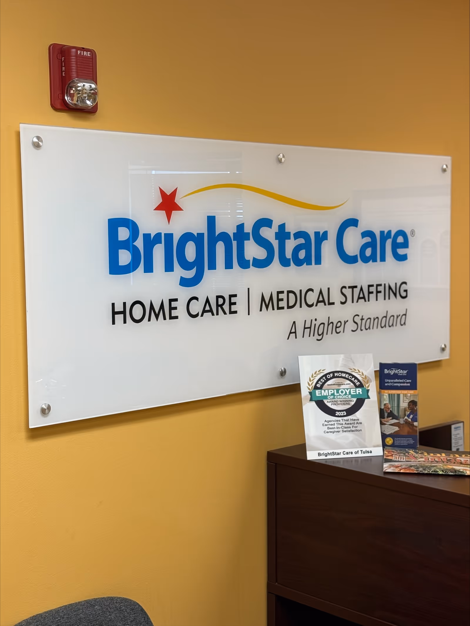 Indoor reception area with BrightStar Care sign and brochures on a desk.