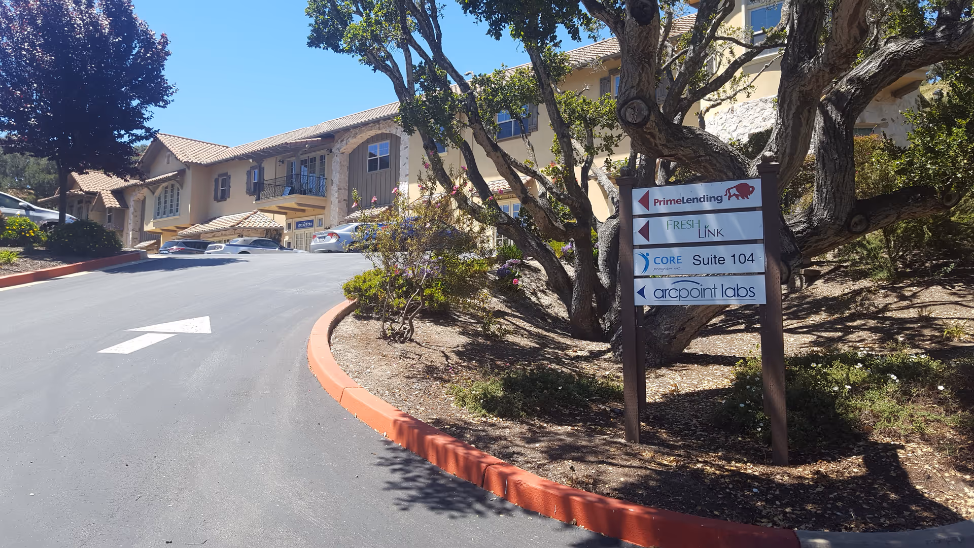 Exterior view of a senior facility with a curved driveway and ARCpoint Labs sign