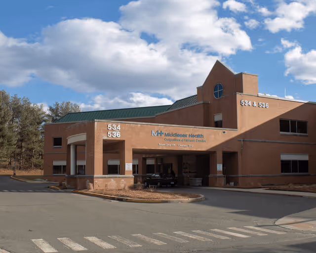 Exterior view of Middlesex Health Cardiac Rehabilitation building with brick facade and parking.