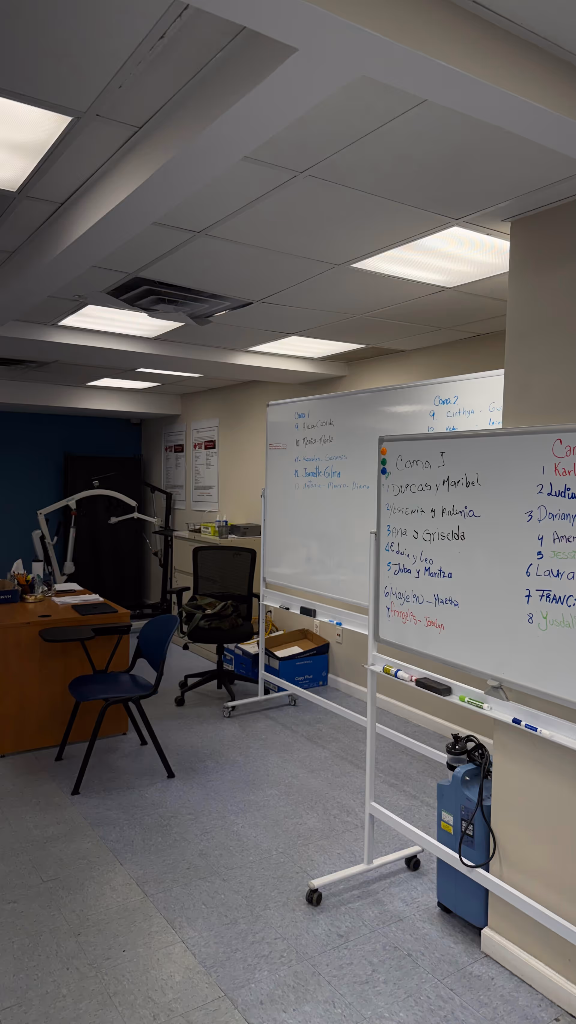 Interior room with whiteboards, desks, chairs, and exercise equipment in a care facility.