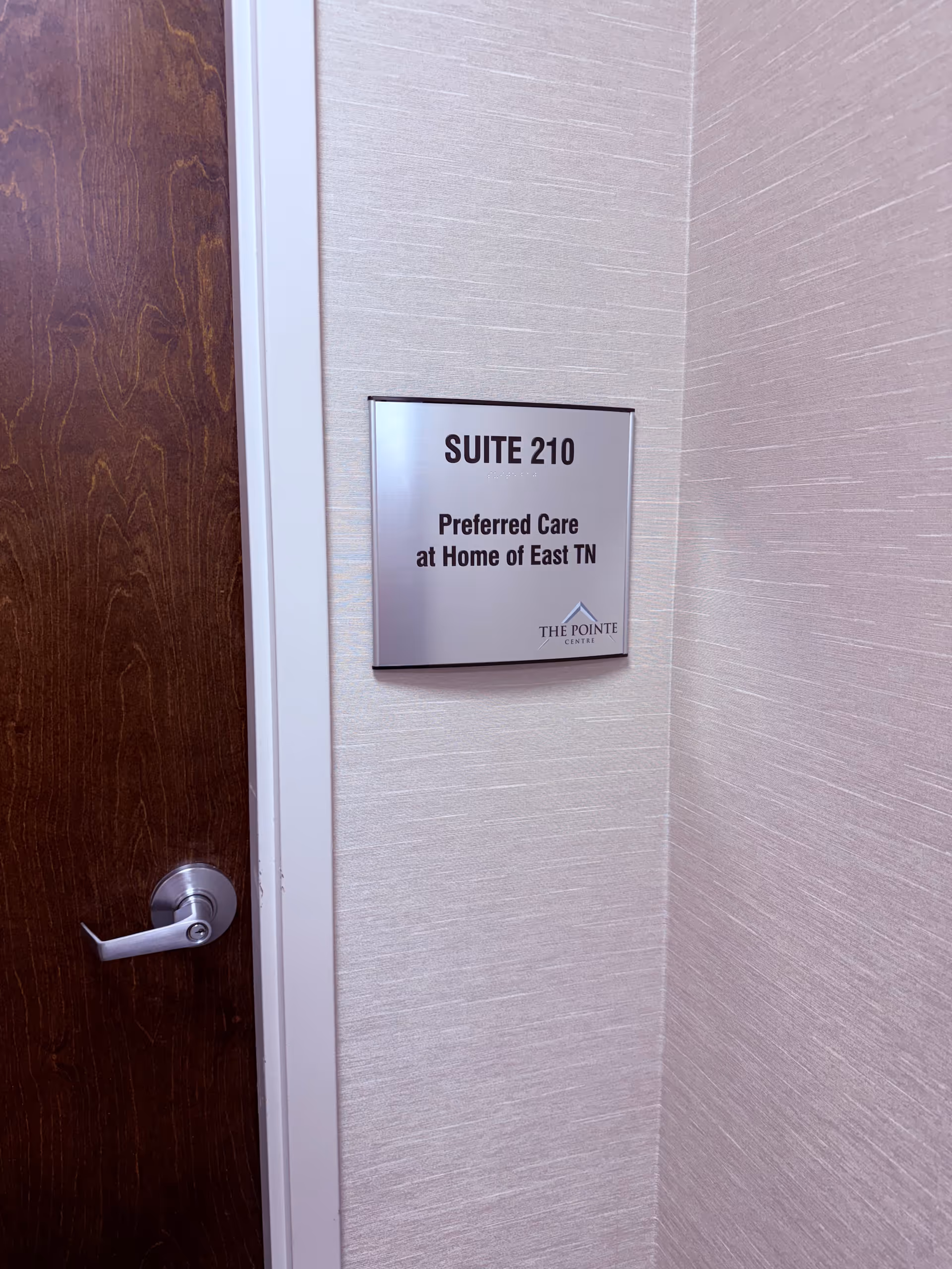 Doorway with wall plaque reading Suite 210 for Preferred Care at Home of East TN.
