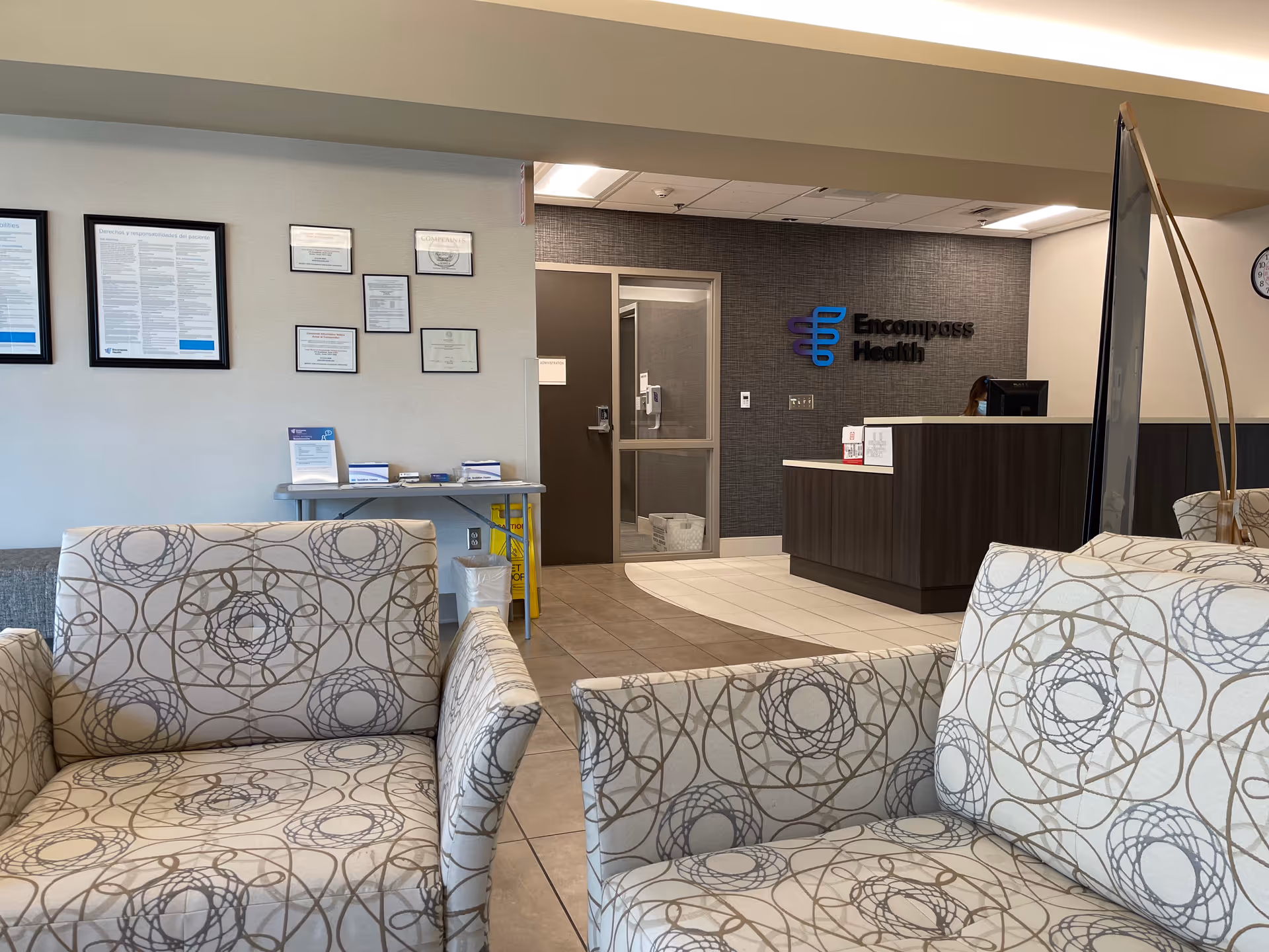 Lobby area with reception desk, patterned chairs, and framed certificates at Enhabit Home Health.