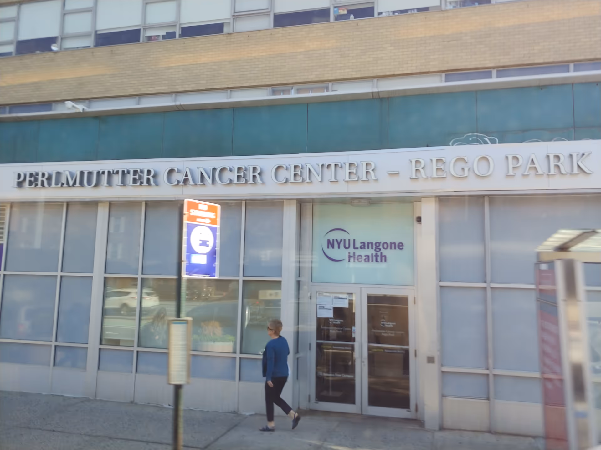 Exterior of NYU Langone Ambulatory Care Rego Park with signage and a pedestrian.