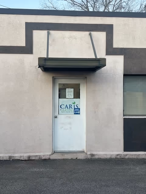 Exterior view of a building entrance with a Caris Healthcare sign on the door.