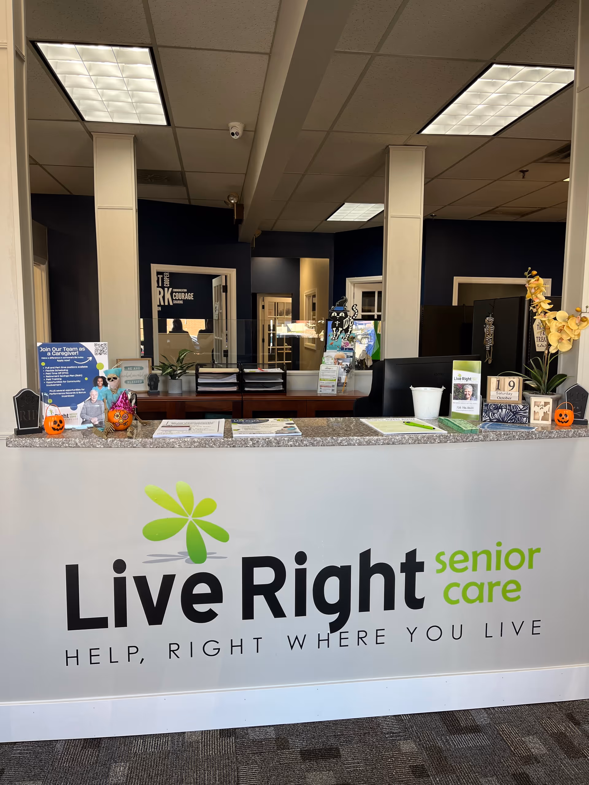 Reception desk in a facility lobby with Live Right Senior Care branding.