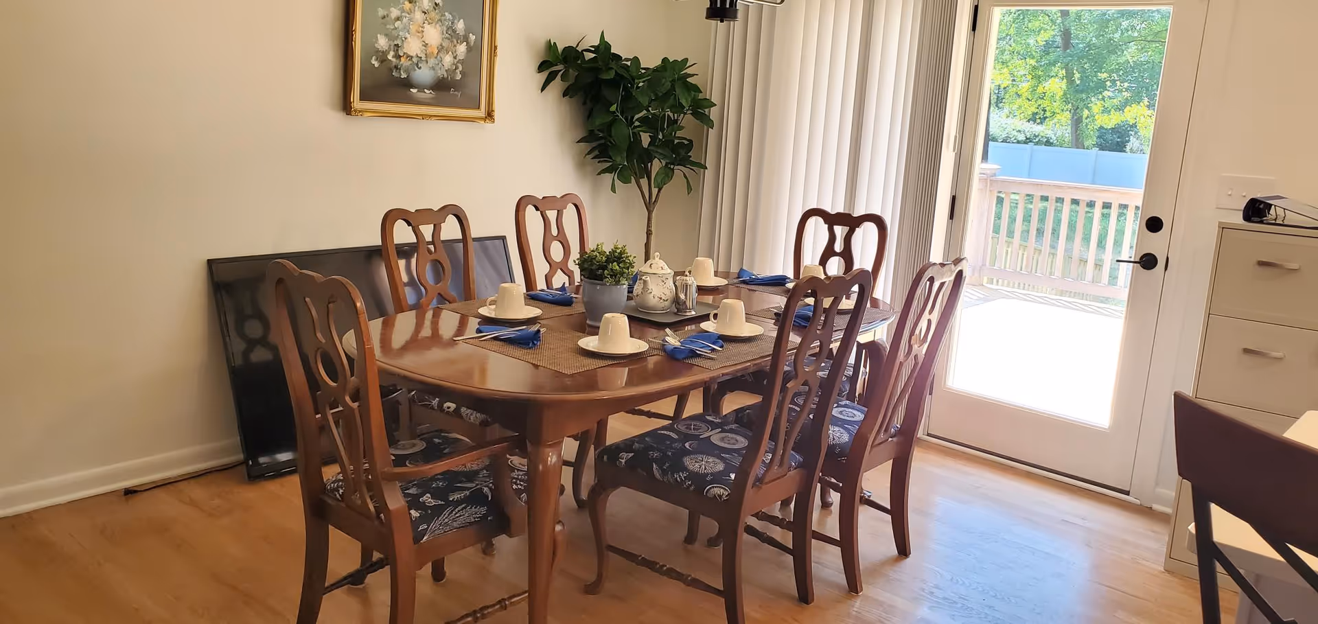 Wooden dining table with chairs set for a meal in a bright dining room.