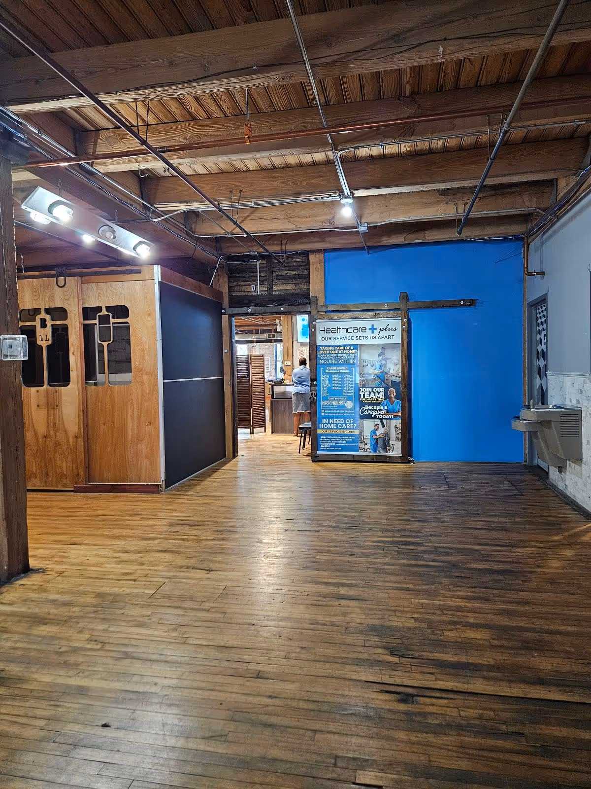 Interior hallway of Healthcare Plus Caregivers with wood floors and blue wall.