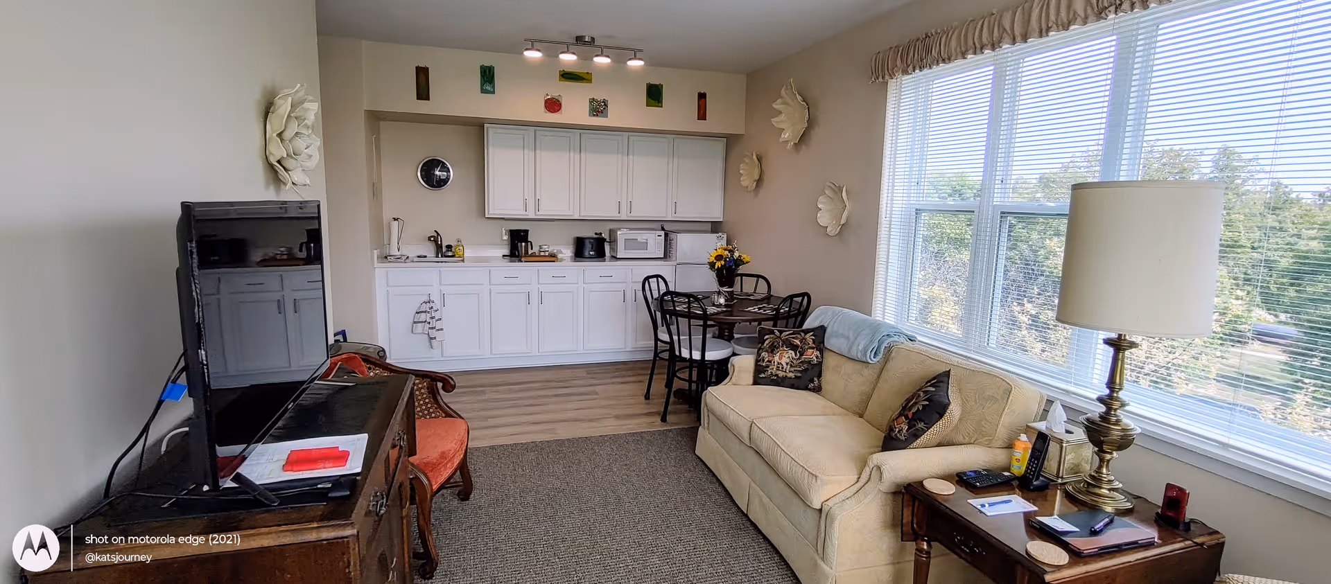 Bright living room in a senior facility with sofa and large windows.