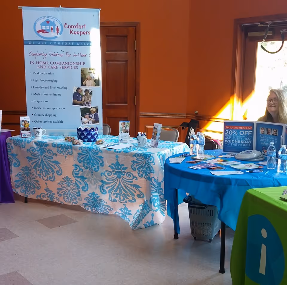 Indoor event booth for Comfort Keepers Home Care with banners and tables set up