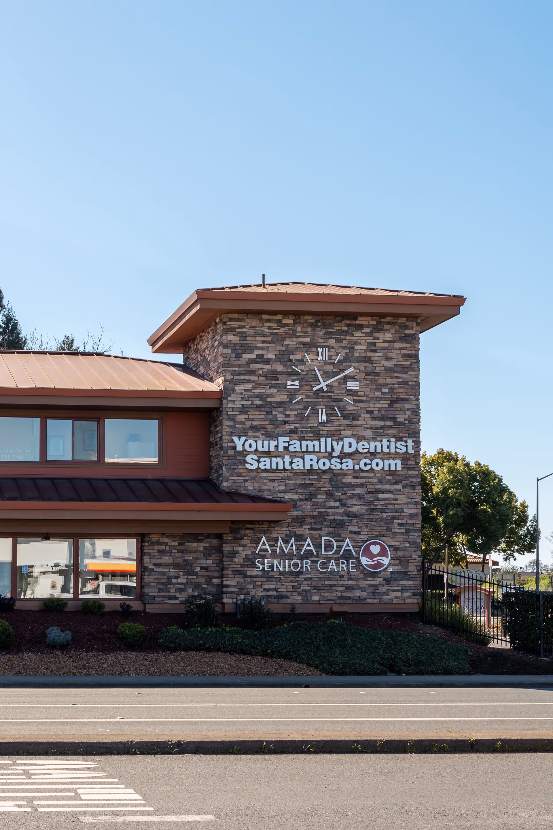 Exterior view of Amada Senior Care building with stone facade and signage