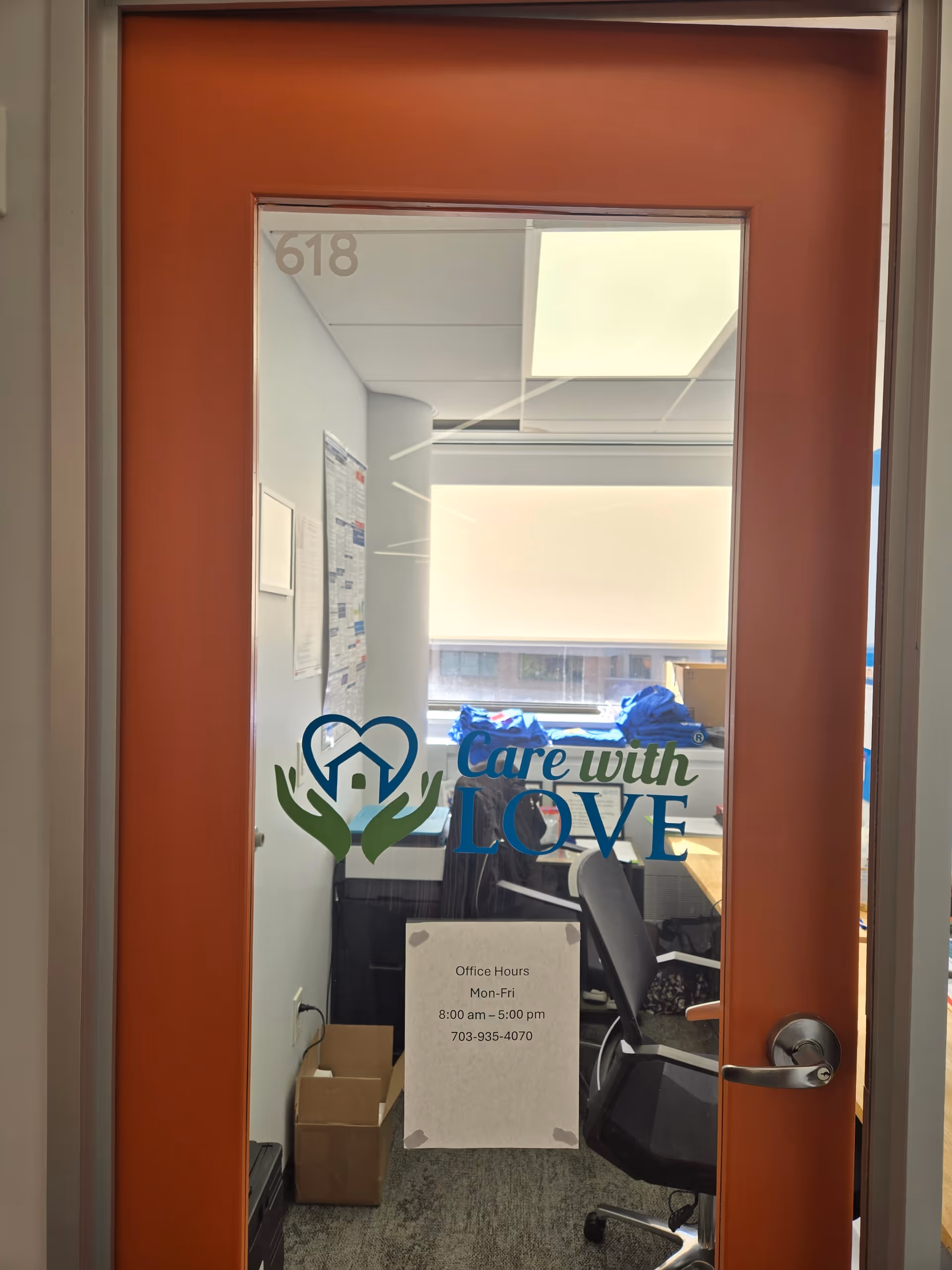 Orange-framed glass door displaying Care with Love logo; office interior and room 618 visible.