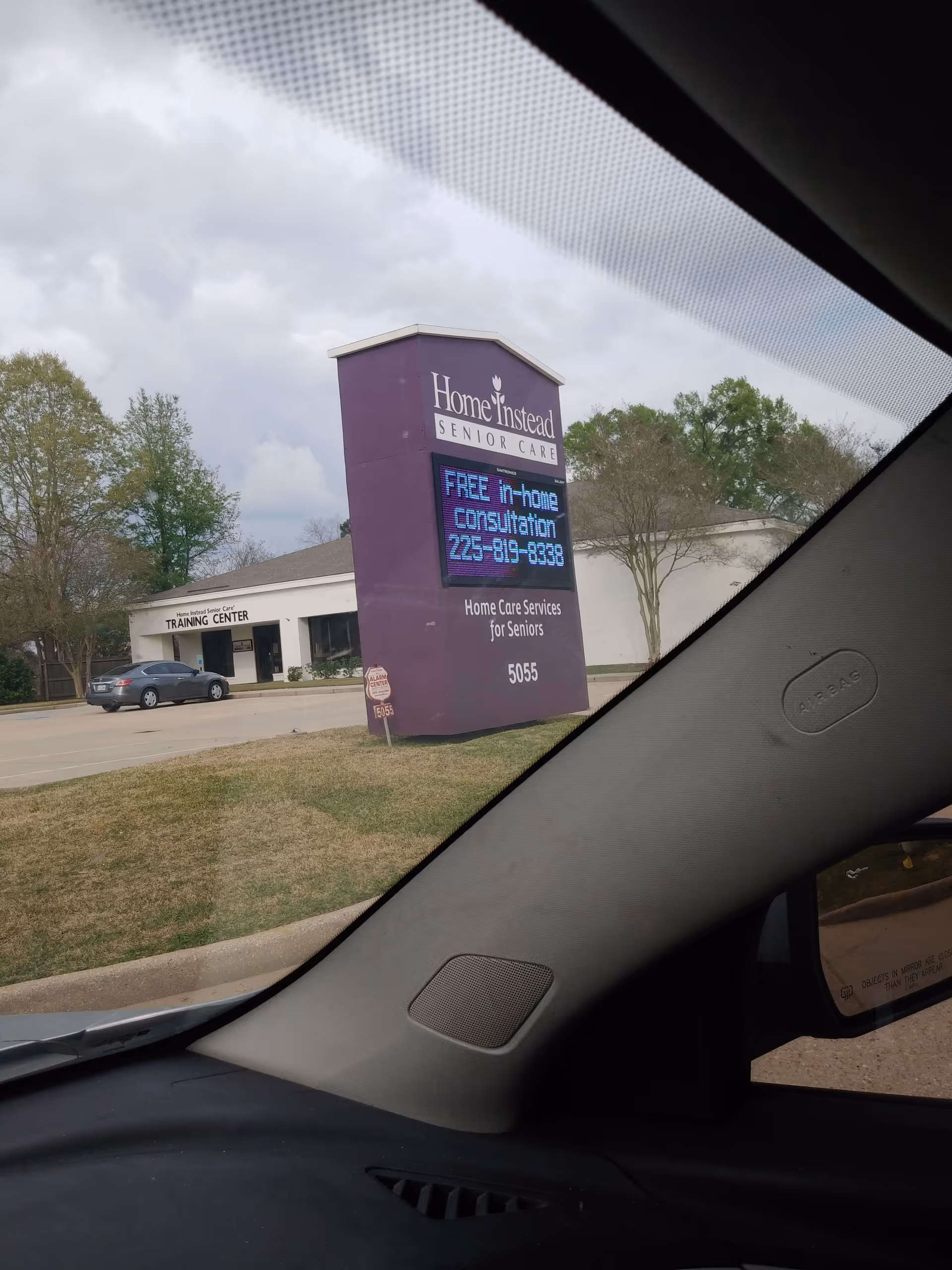 From inside a car, a purple Home Instead sign and front entrance are visible.