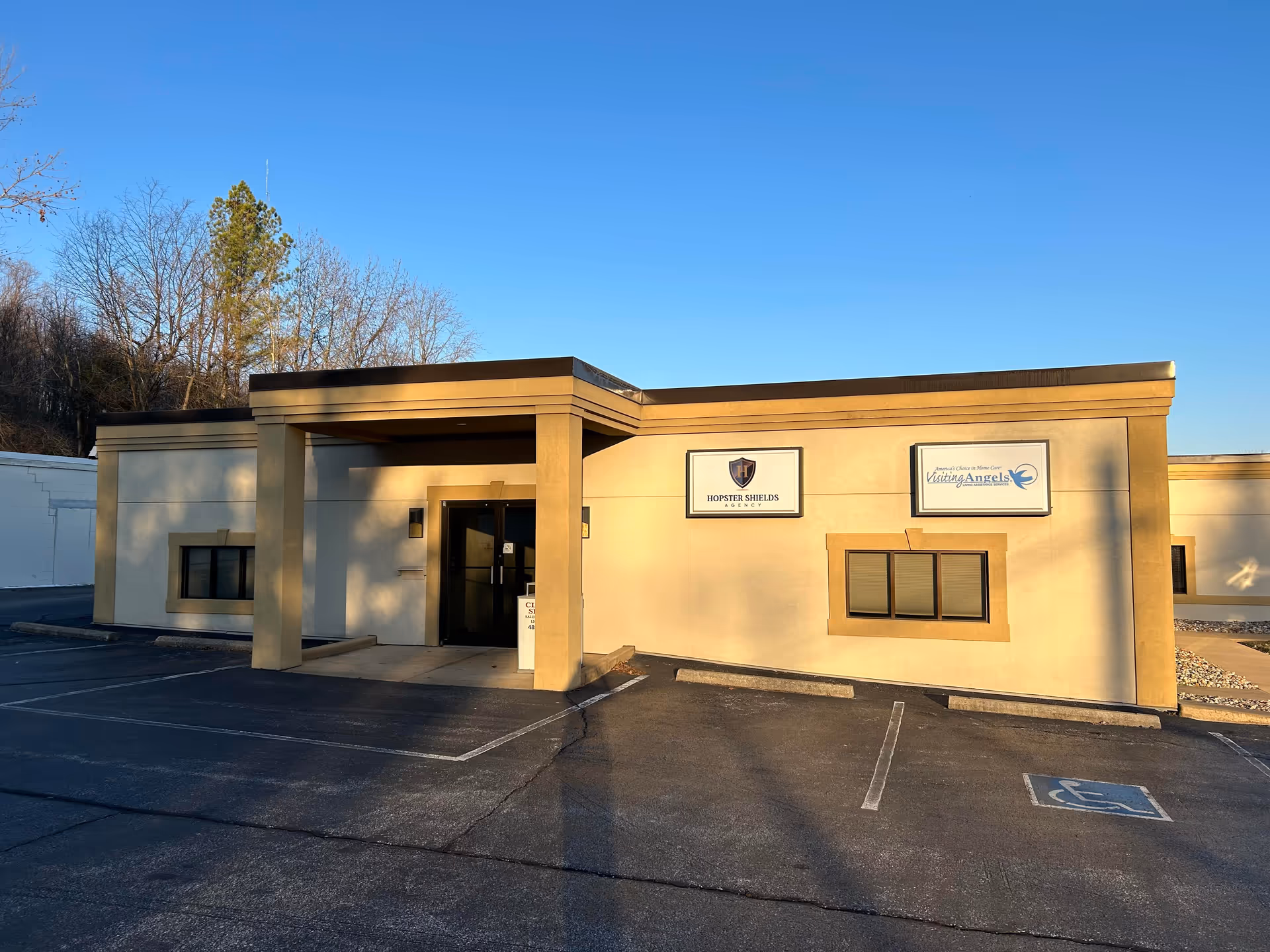 Front exterior of a beige Visiting Angels Senior Home Care building with signs