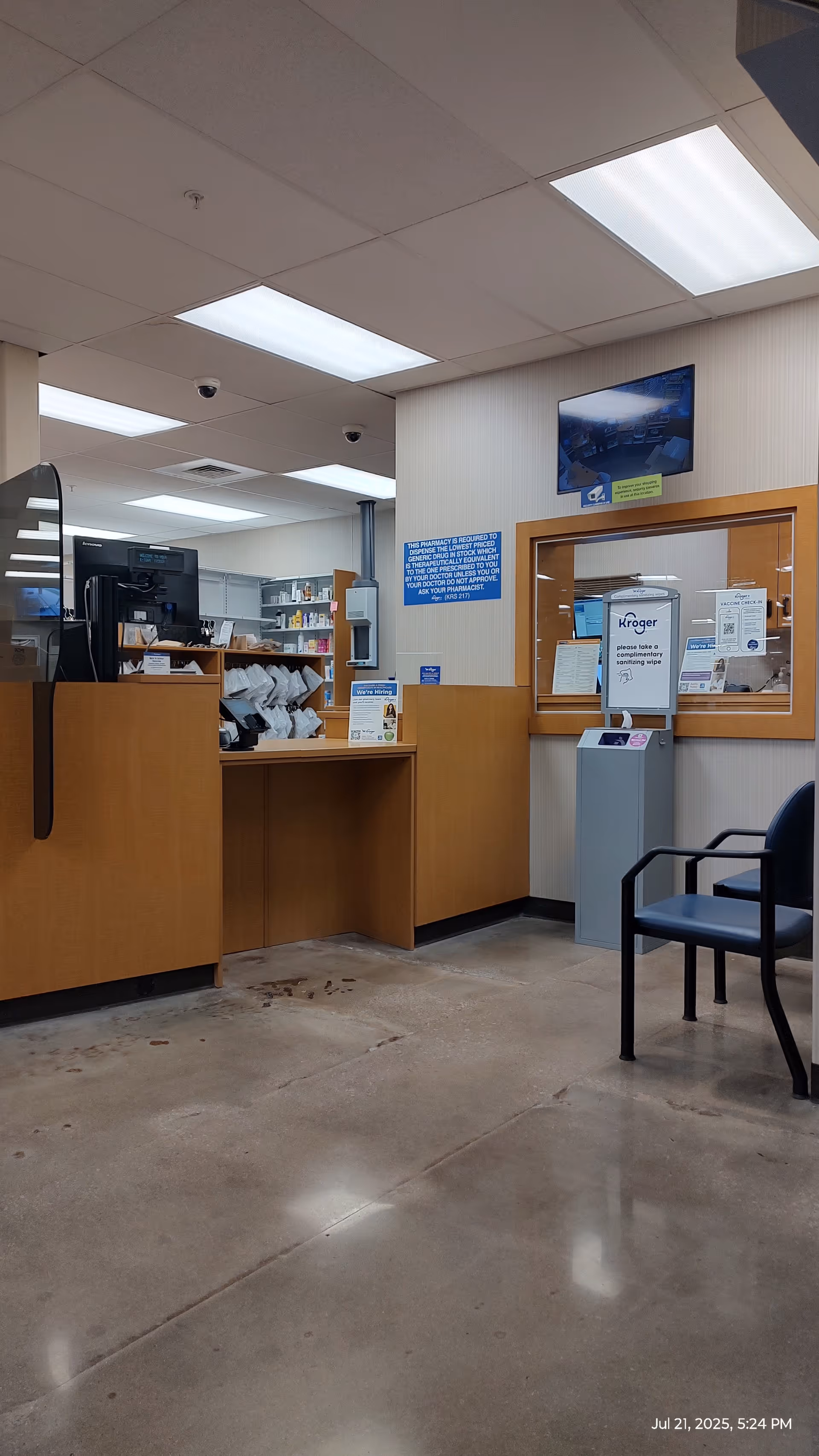 Interior of a Kroger Pharmacy counter in a senior living facility with chairs.