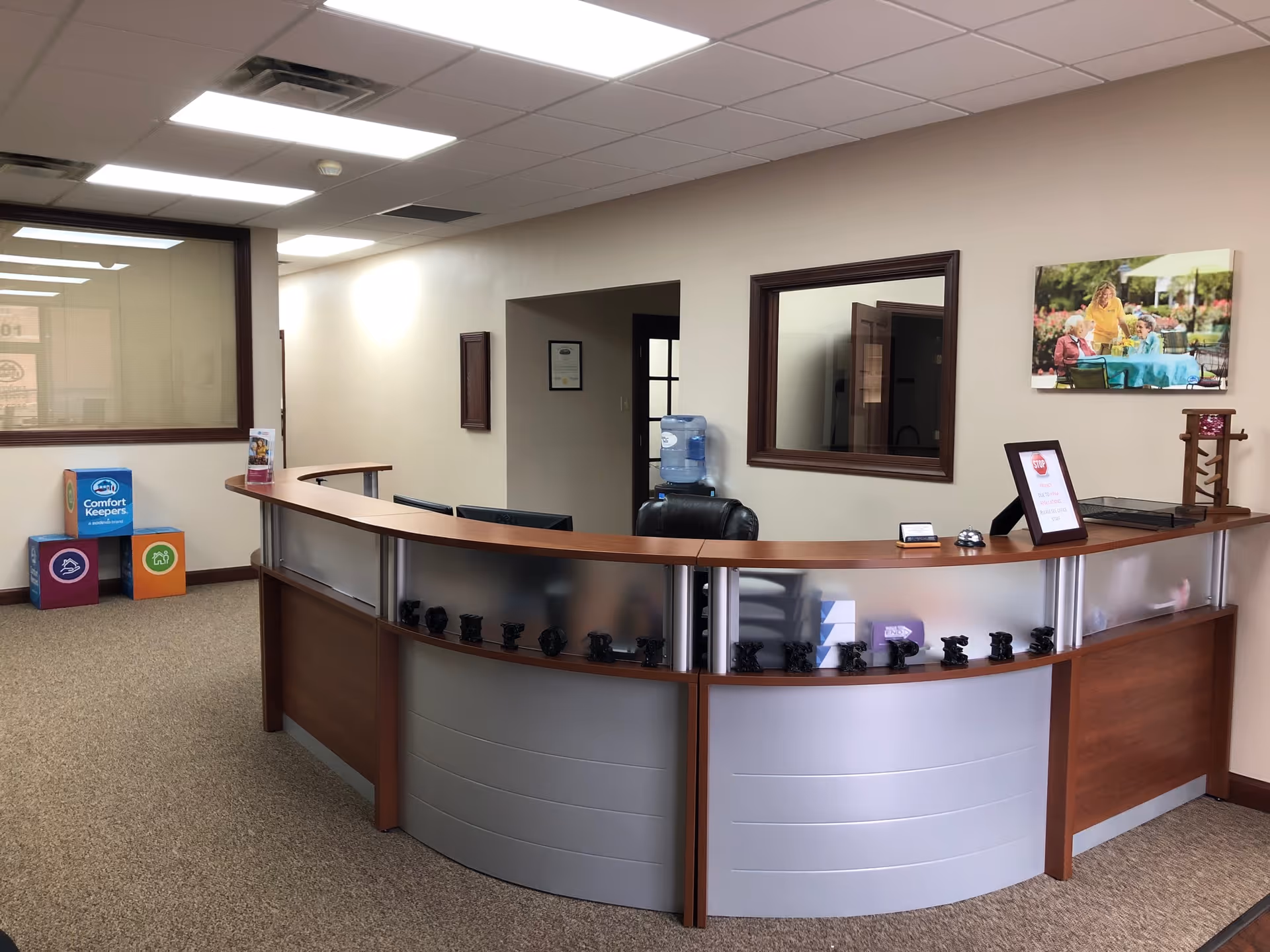 Curved reception desk in a Comfort Keepers Home Care lobby with framed art.