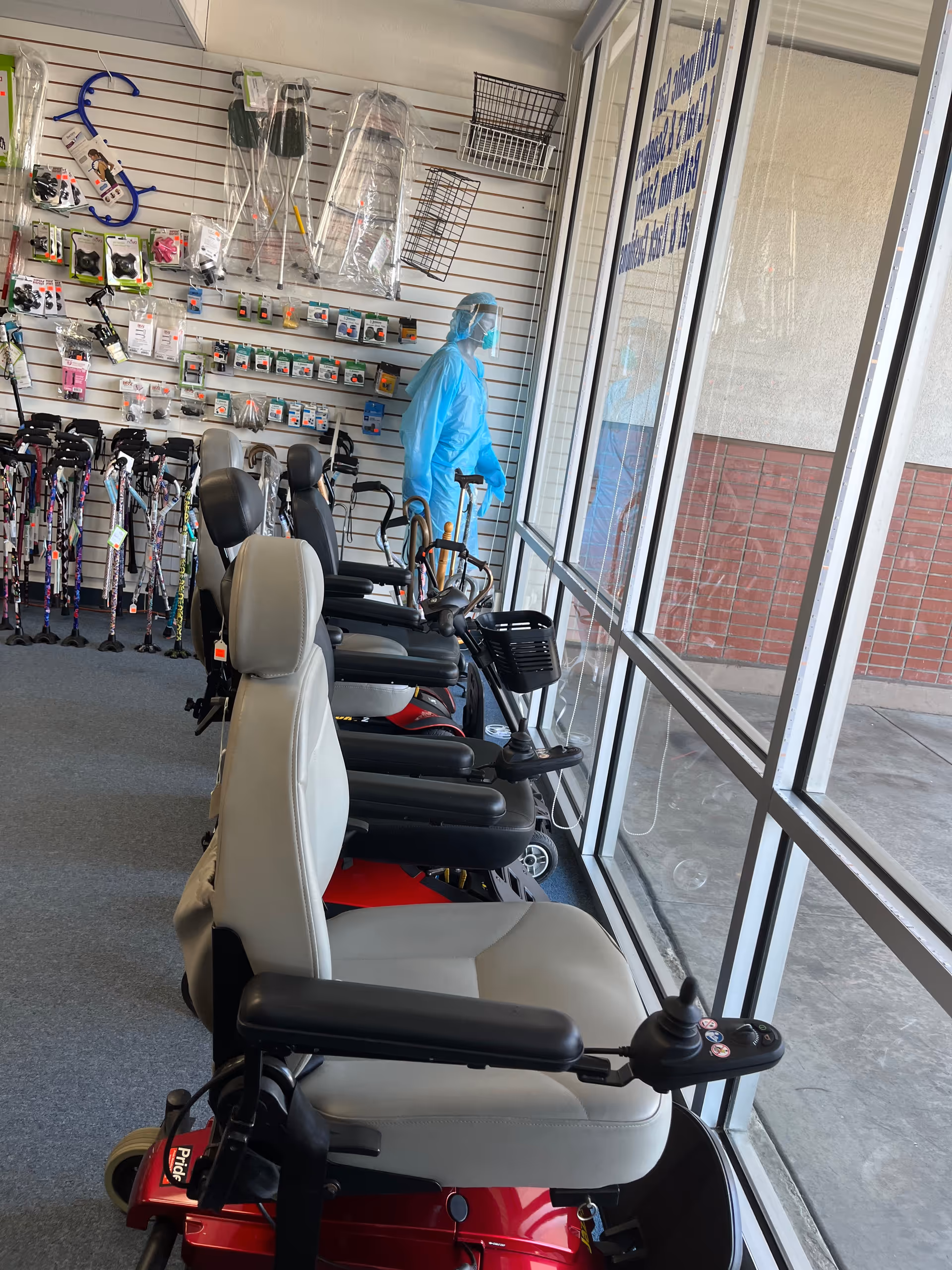 Inside a medical supply showroom with mobility scooters lined along large windows.