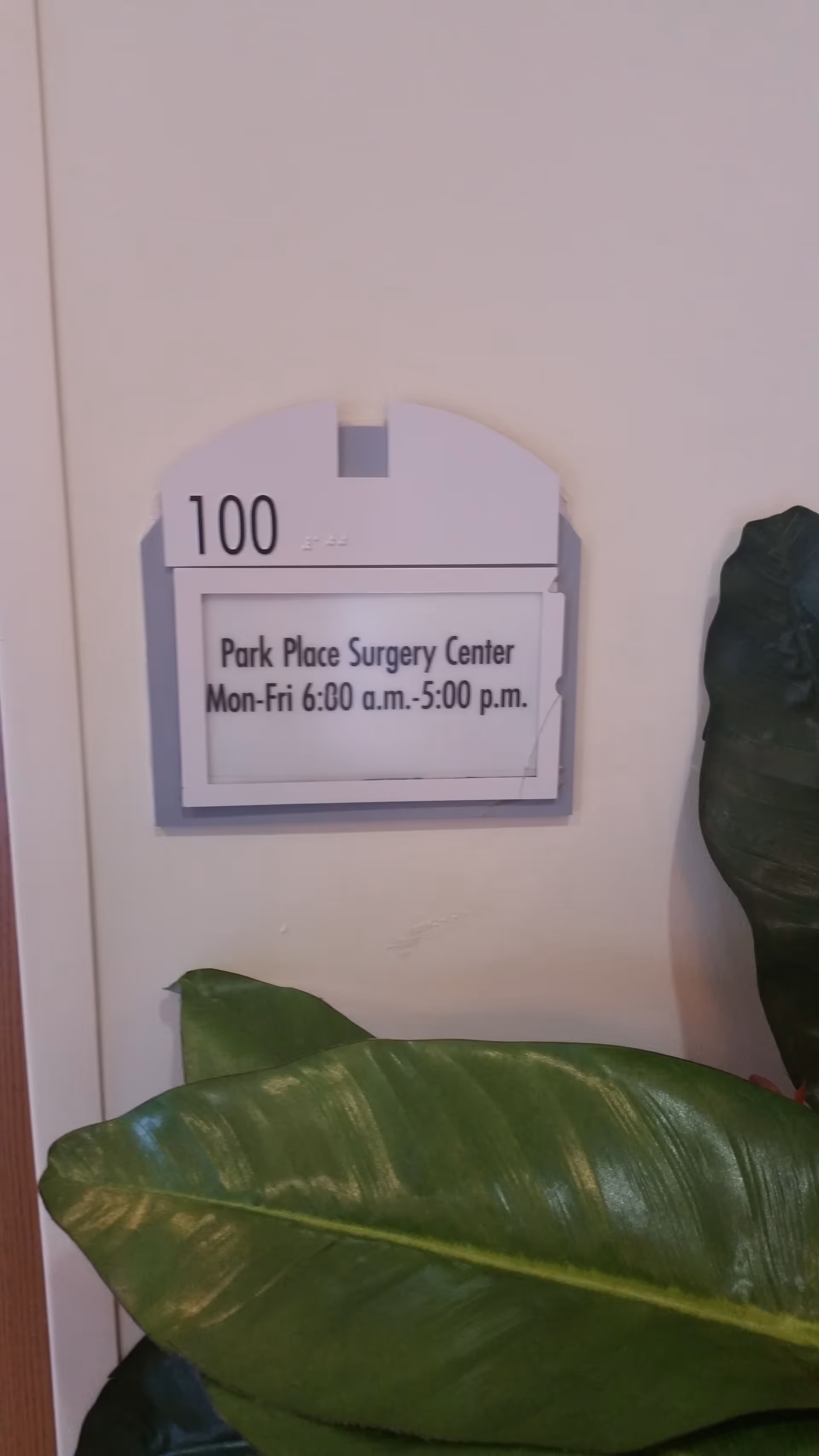 Interior wall sign showing Park Place Surgery Center hours and door number 100.