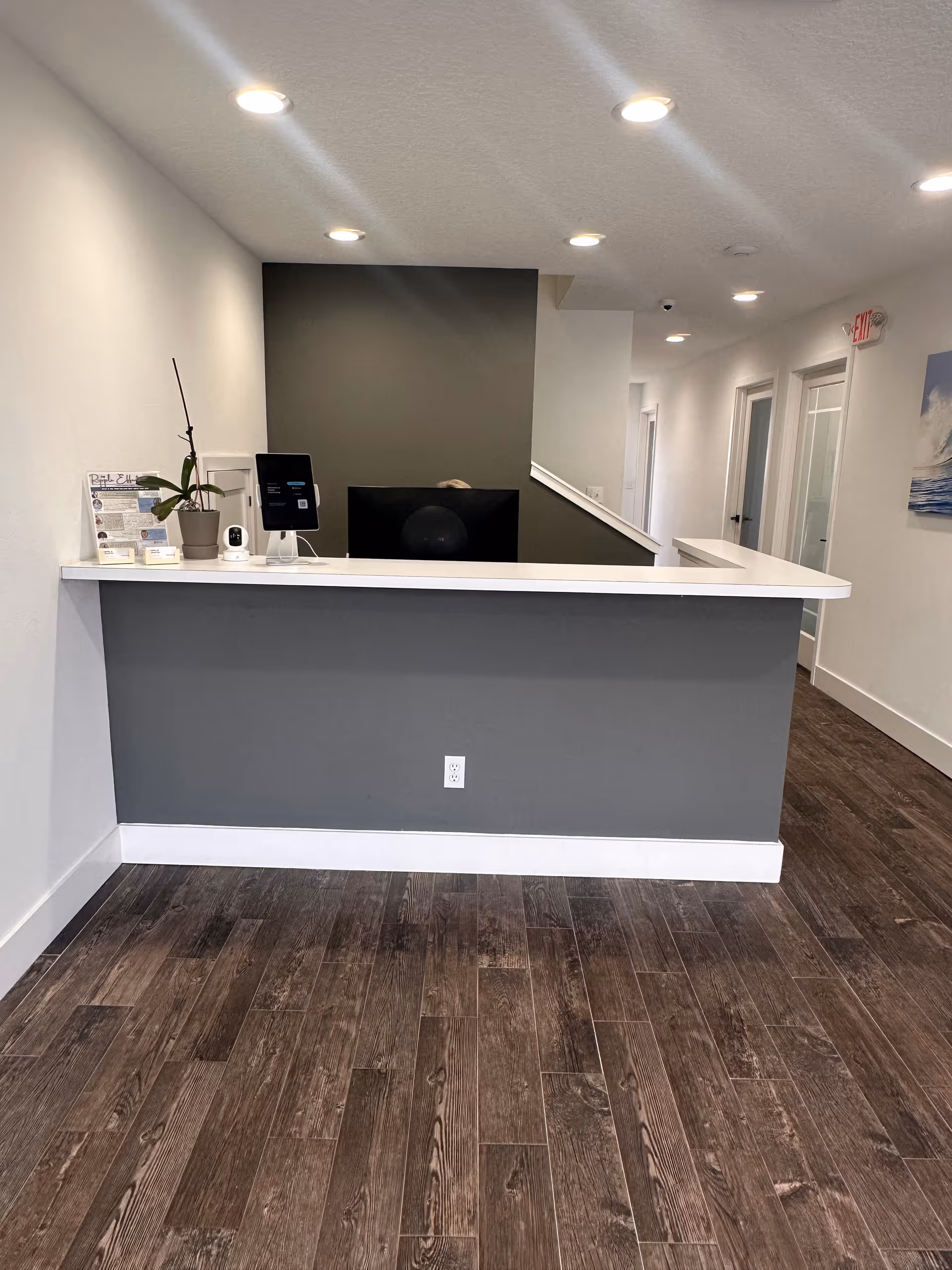 Reception desk in a senior living facility lobby with computer, plant, and brochures.