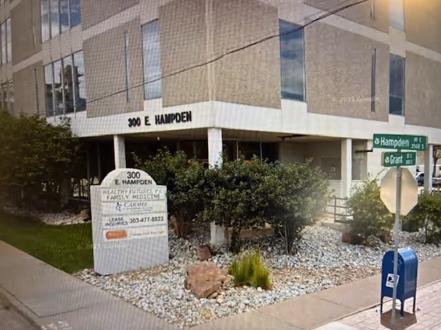 Exterior view of a Comfort Keepers Home Care building with landscaping and street signs.