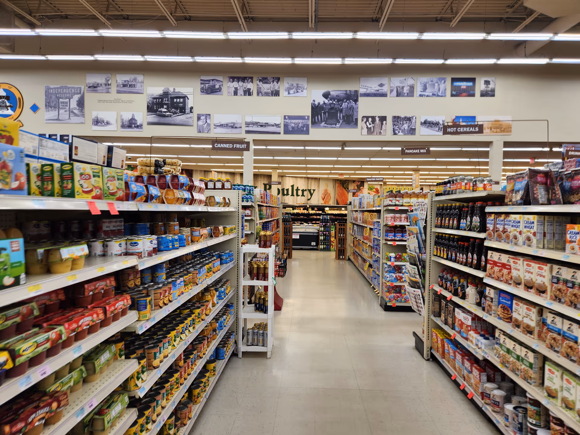 A grocery store aisle with shelves stocked full of canned goods and cereals