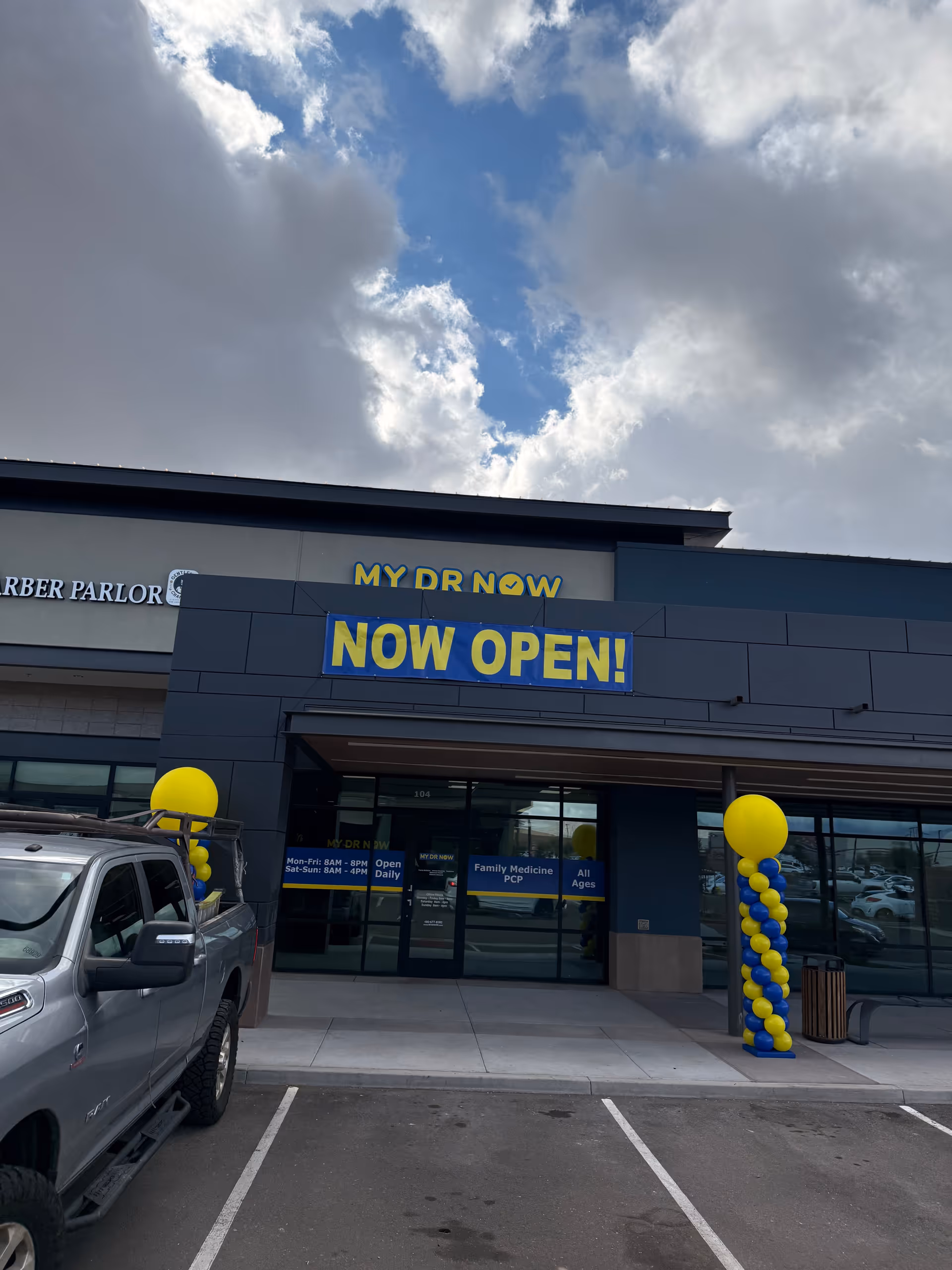 Exterior view of MY DR NOW storefront with NOW OPEN banner and balloons