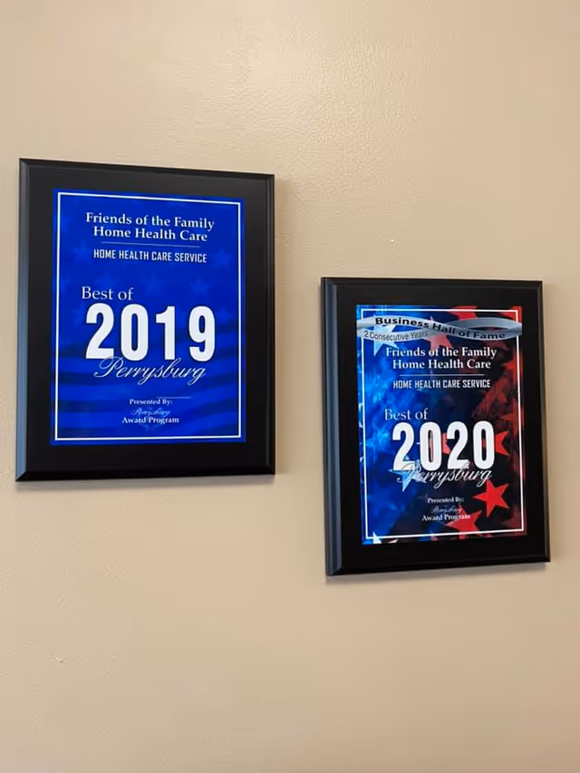 Beige wall with two framed awards for Friends of the Family Home Health Care.