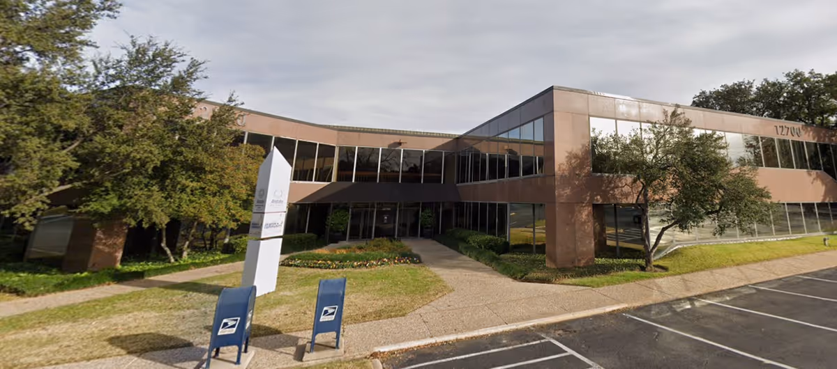 Exterior of a Senior Helpers building with glass windows and a walkway entrance.