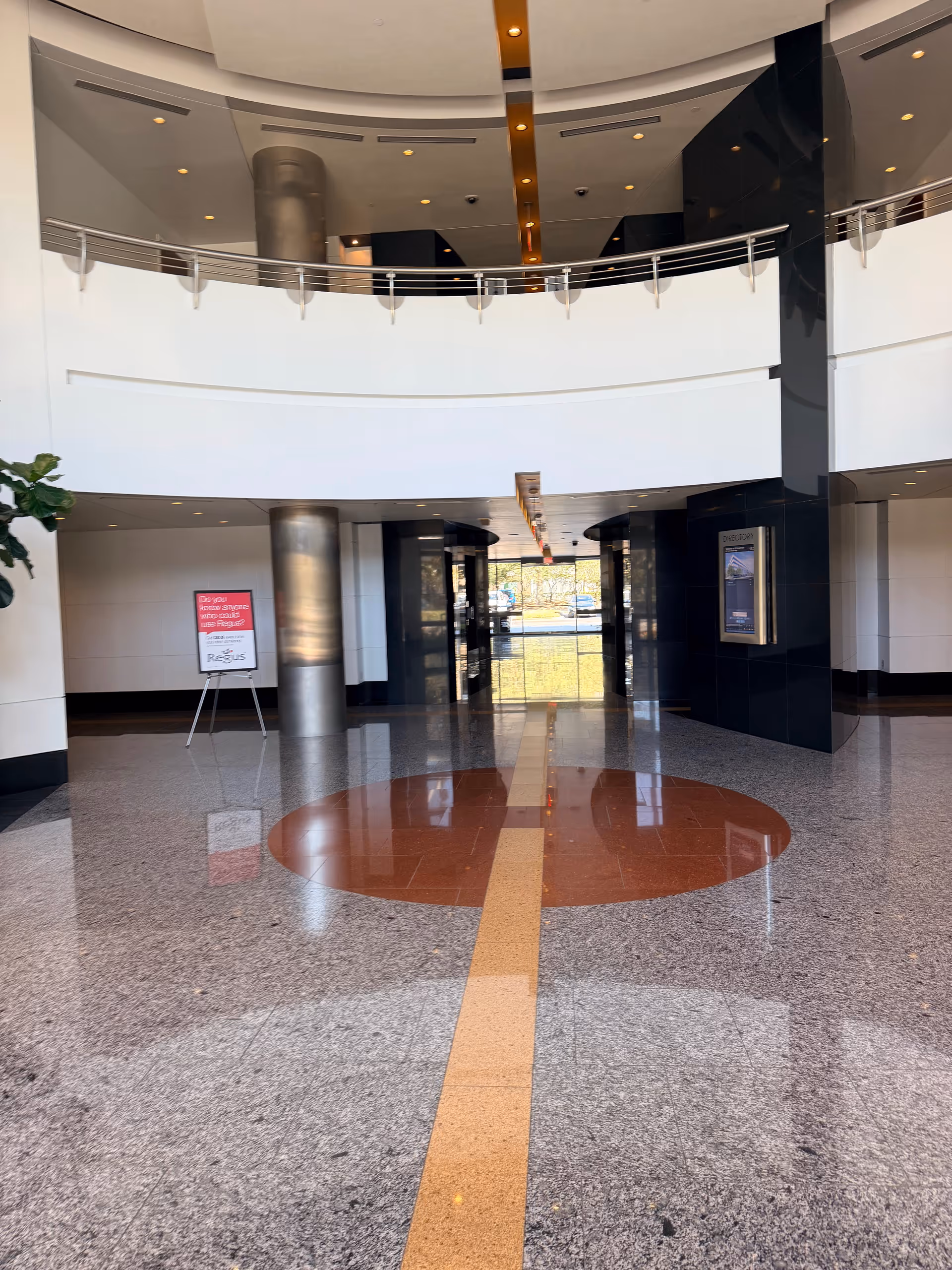 Modern hotel-style lobby interior with polished floors and curved white walls.