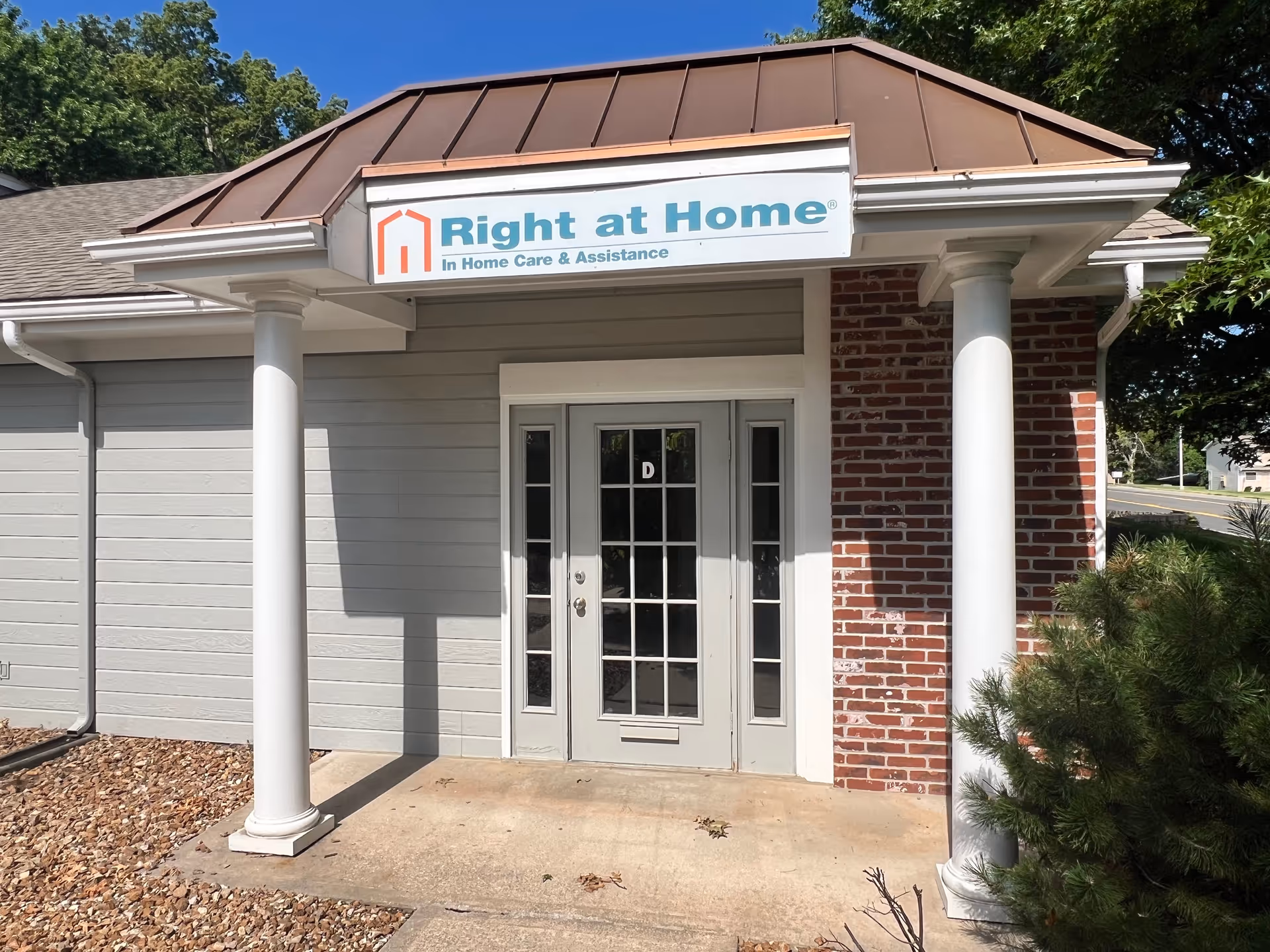 Entrance of a Right at Home facility with brick columns and a sign.
