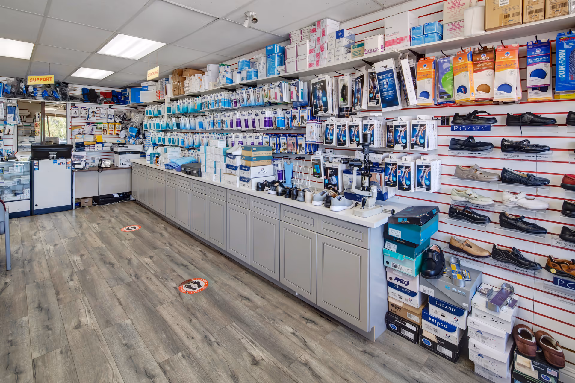 Interior of a medical supply store with long shelves and displayed shoes and accessories.