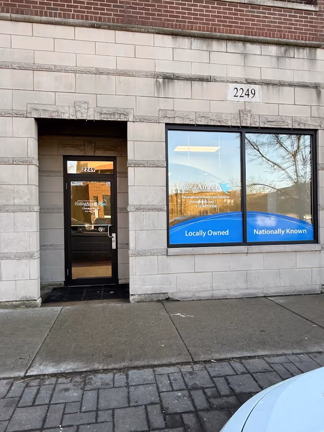 Exterior view of Visiting Angels storefront with glass door and large window displaying branding.