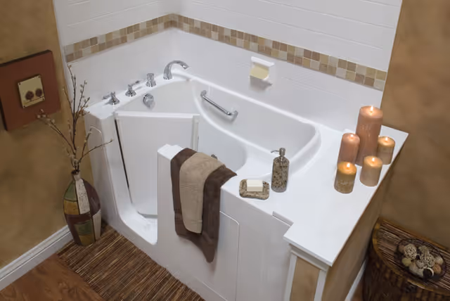 White bathtub with grab bars, towels, and candles in a bathroom.