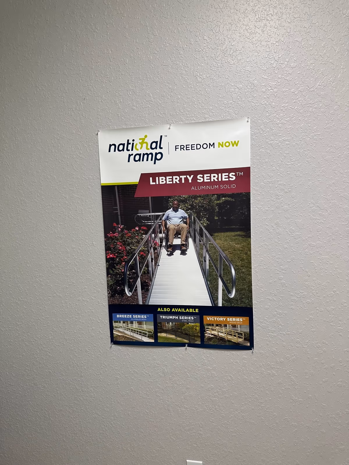 Poster on a textured interior wall advertising National Ramp Liberty Series with a wheelchair ramp.
