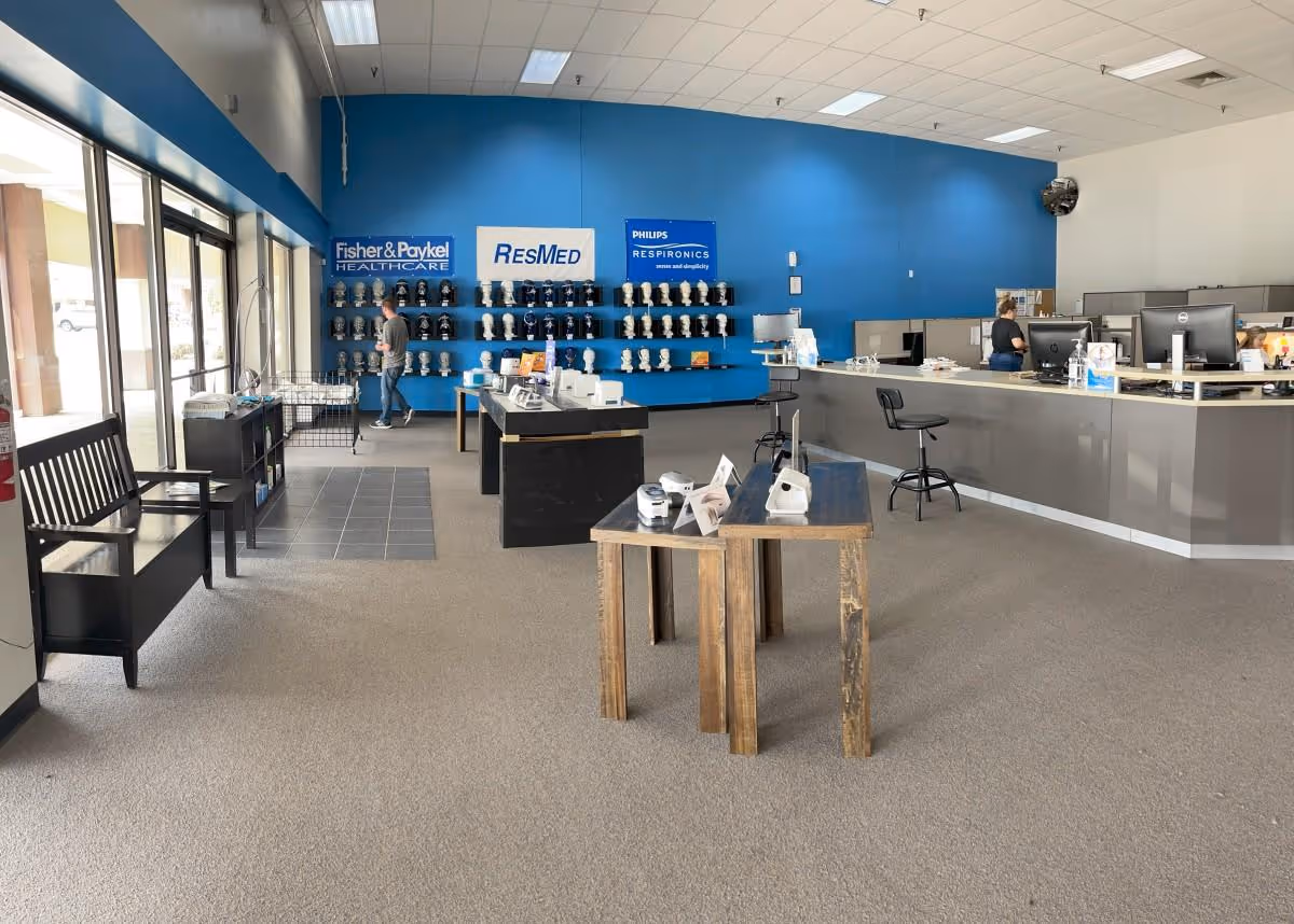 Interior of a CPAP showroom with a blue wall, display shelves, and a reception desk.
