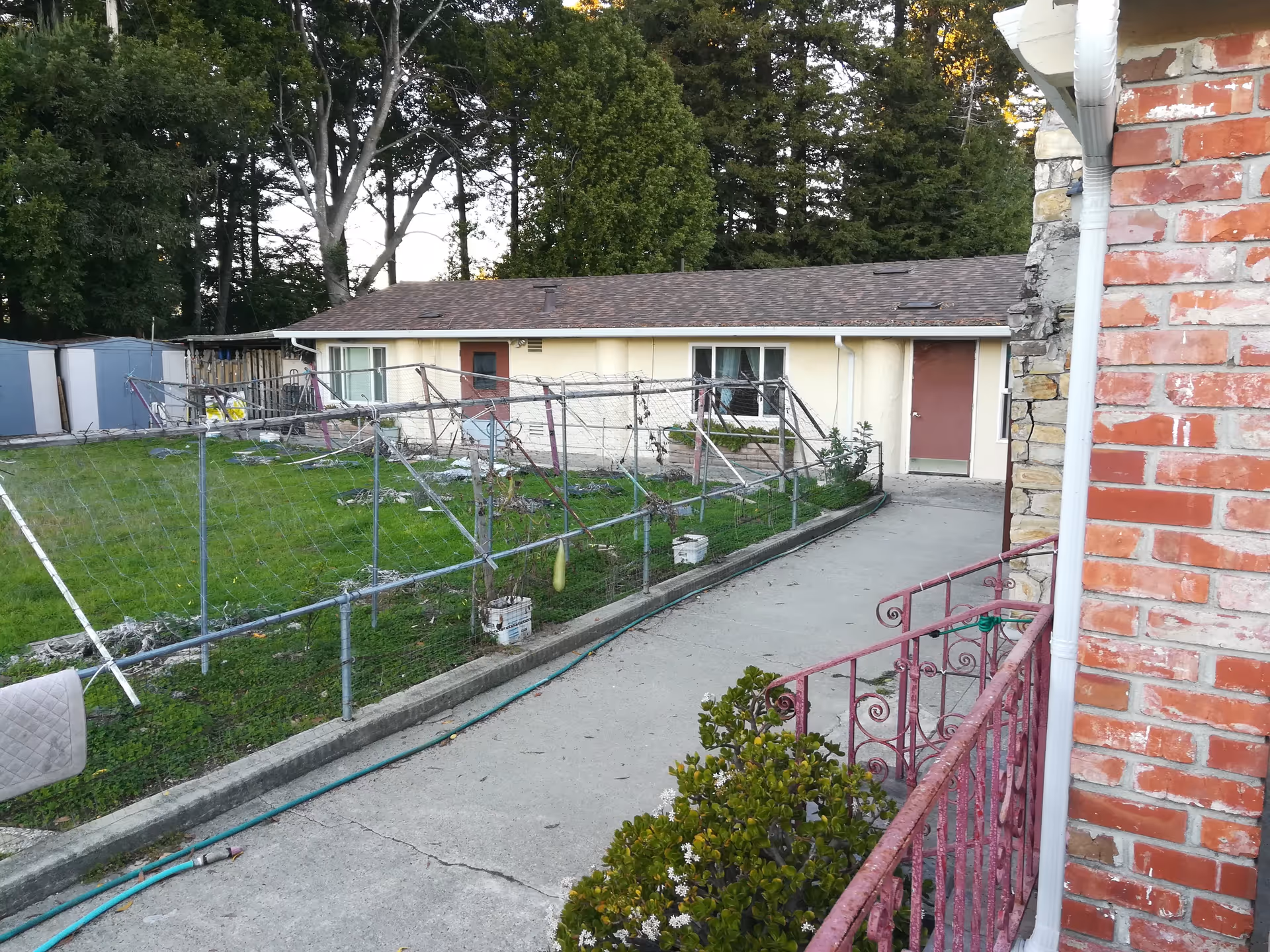 Exterior view of a senior living courtyard with a chain-link fence and doors.