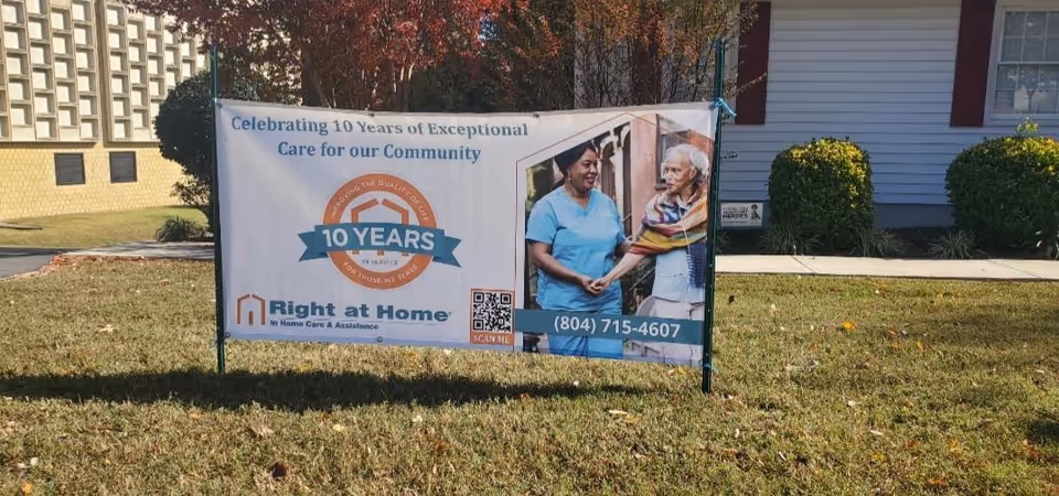 Outdoor banner advertising Right at Home sits on a grassy lawn in front of a facility.