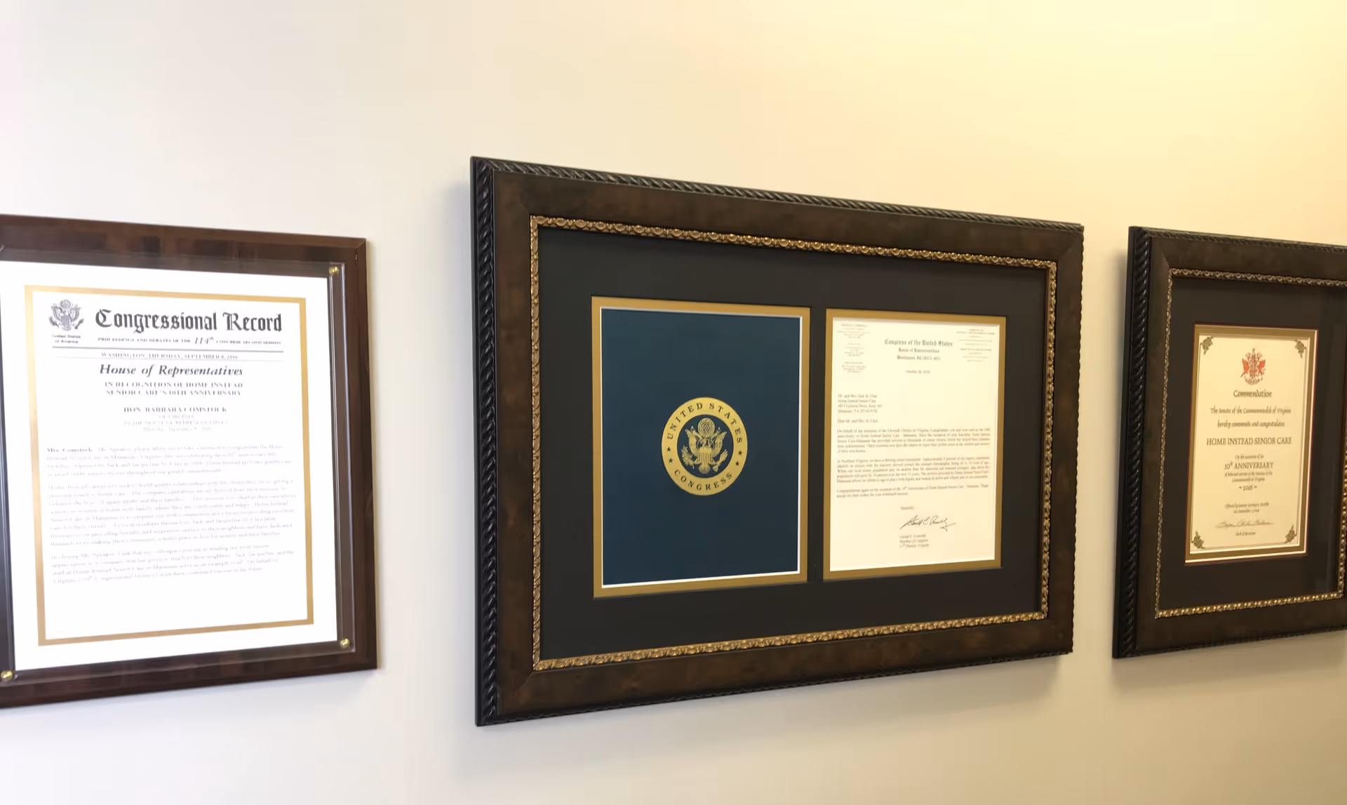 Wall featuring three large framed certificates and documents.