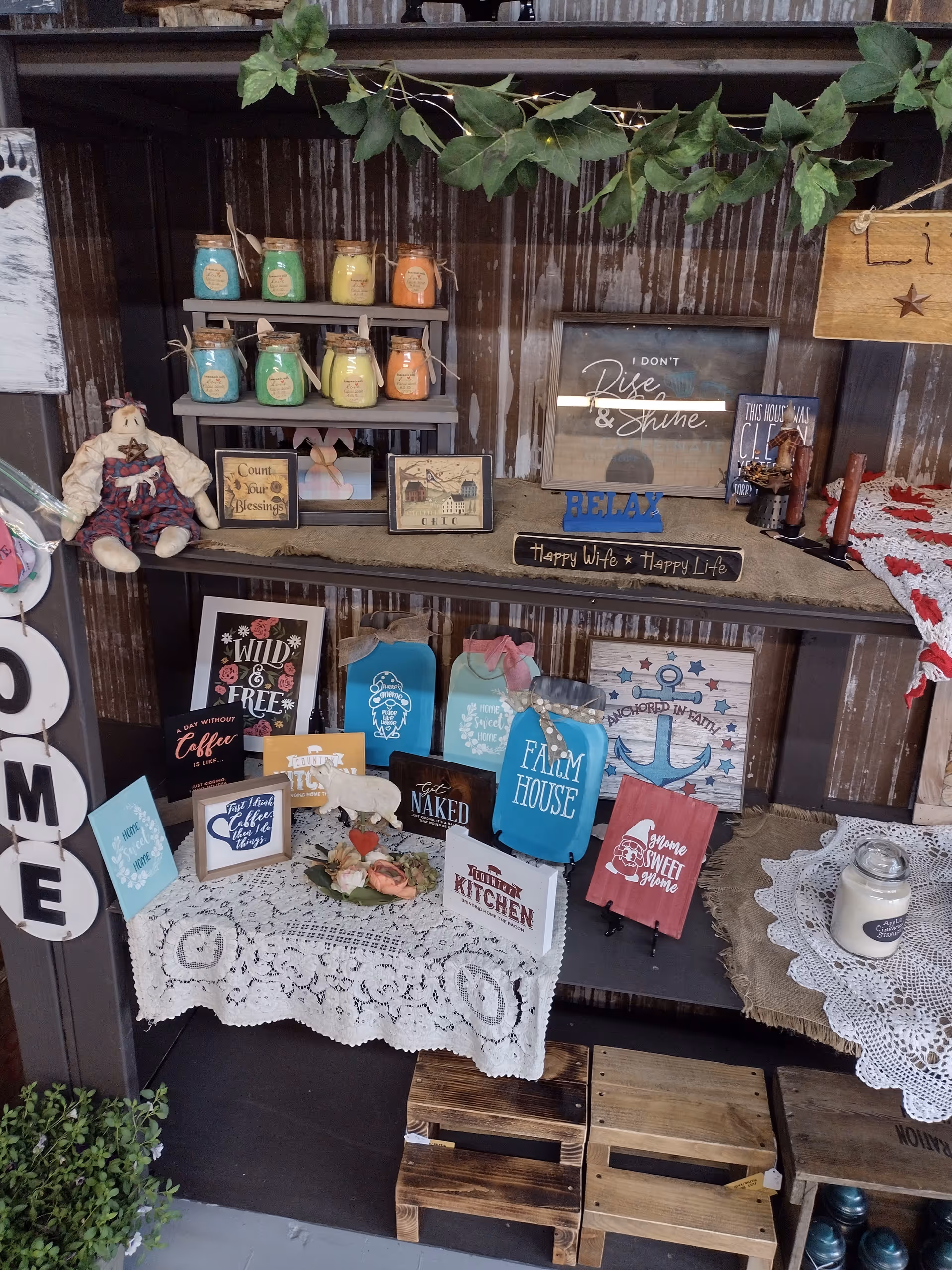 Rustic shelf display with jars, signs, and small décor items.