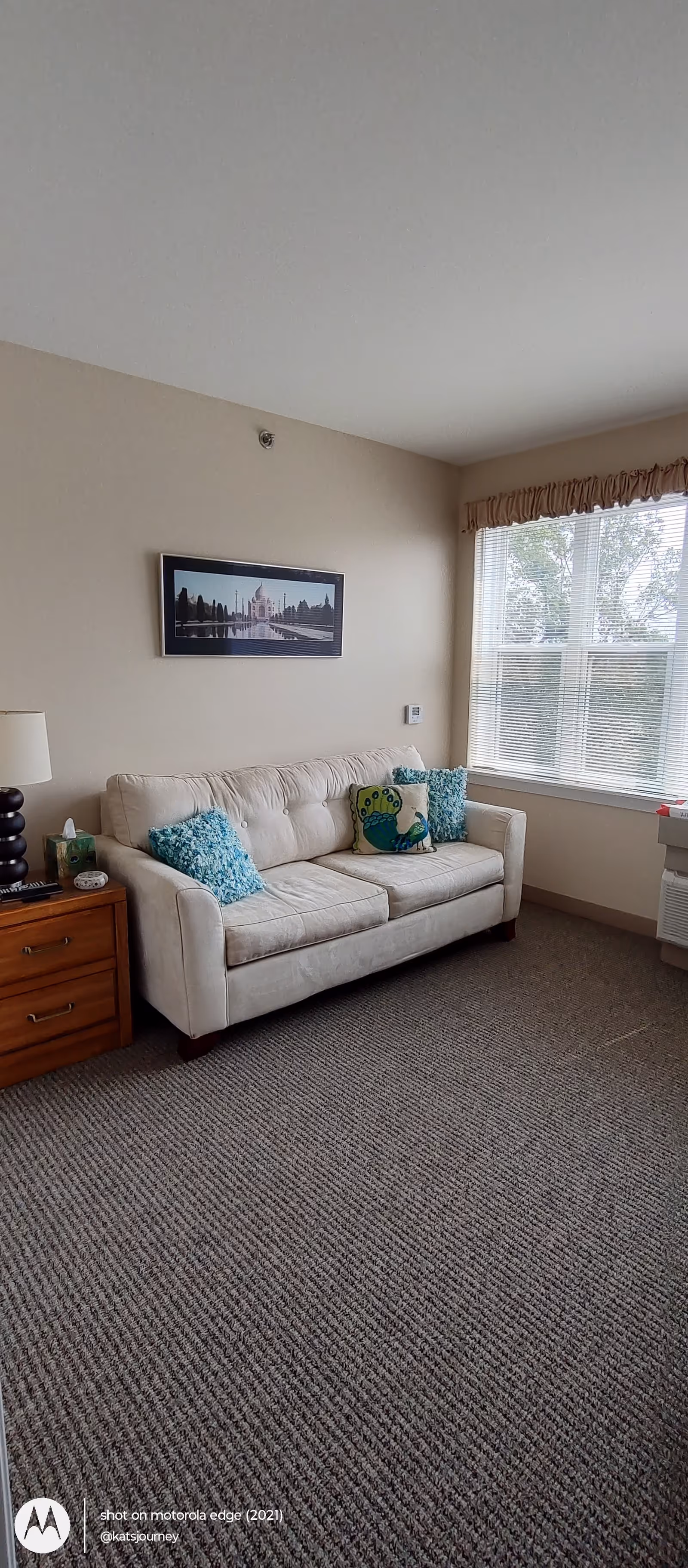 Bright living room at Cantata Adult Life Services with beige sofa and large window.