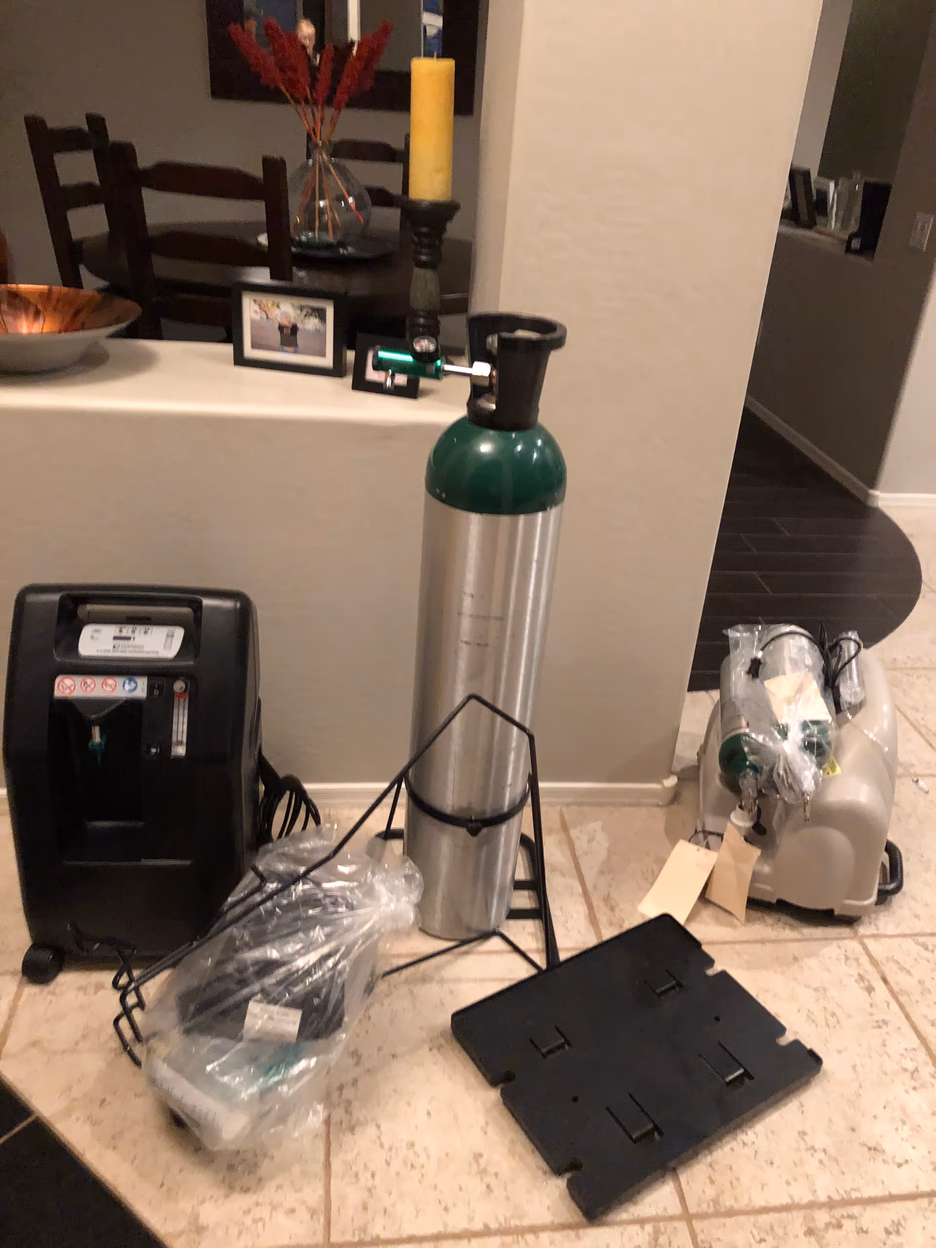 Interior hallway with oxygen tank and medical equipment on tiled floor.