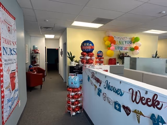 Interior hallway of BAYADA Adult Nursing with nurse appreciation balloons and a reception area