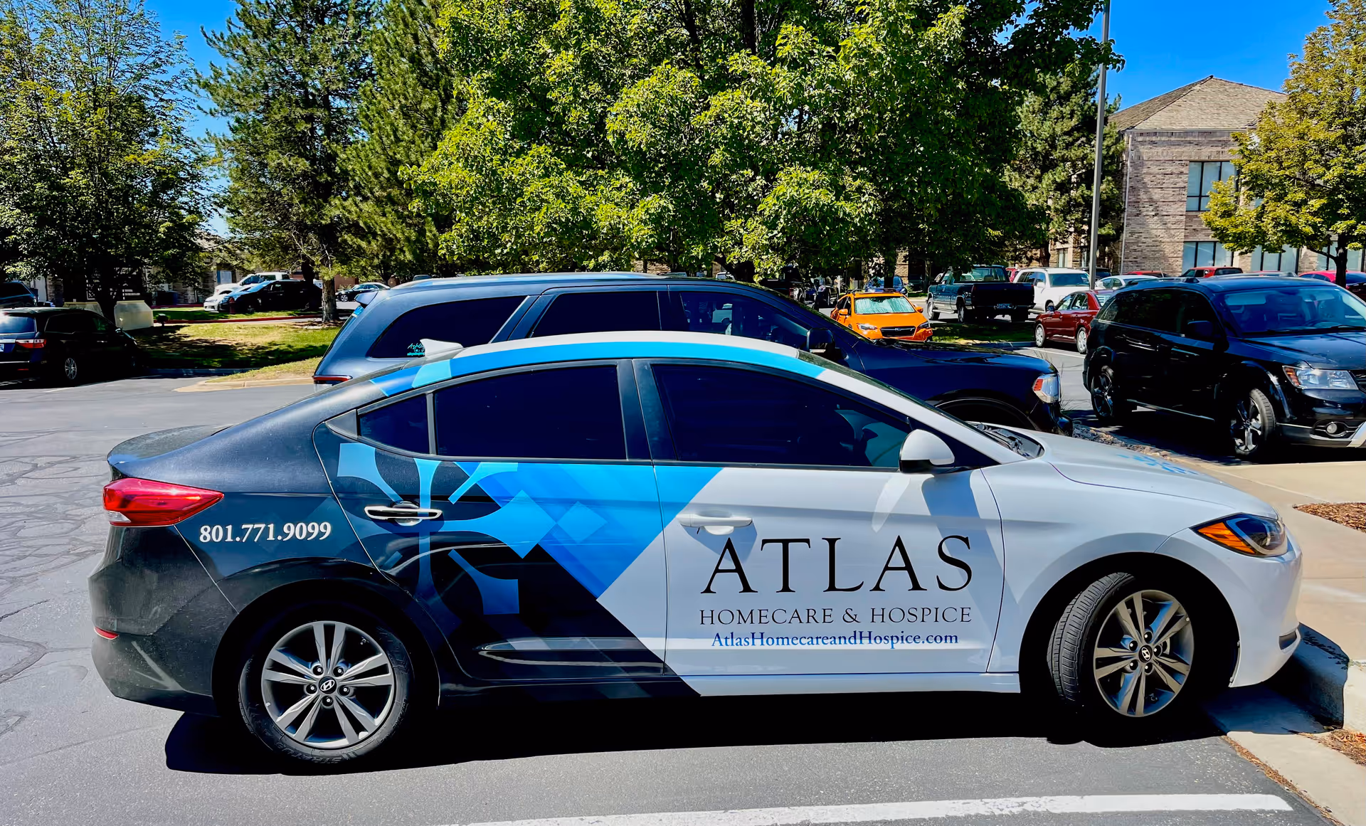 A branded Atlas Homecare and Hospice vehicle parked in a sunny parking lot.