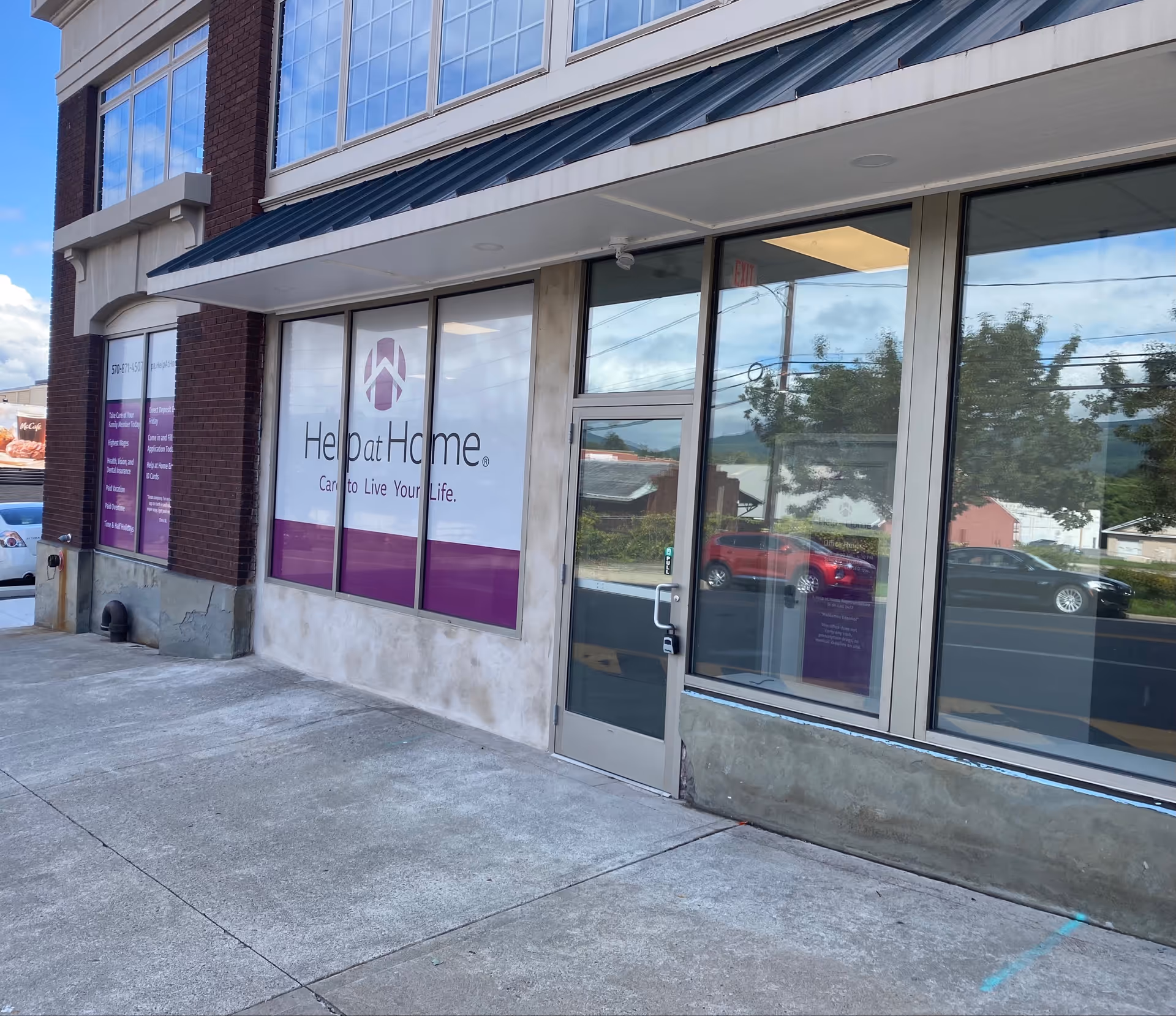 Exterior of Help at Home facility storefront with glass door and windows
