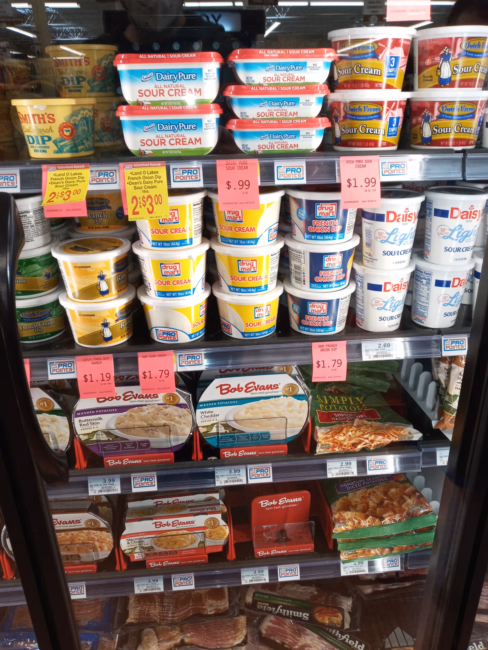 Grocery store shelf stocked with sour cream and other dairy products.
