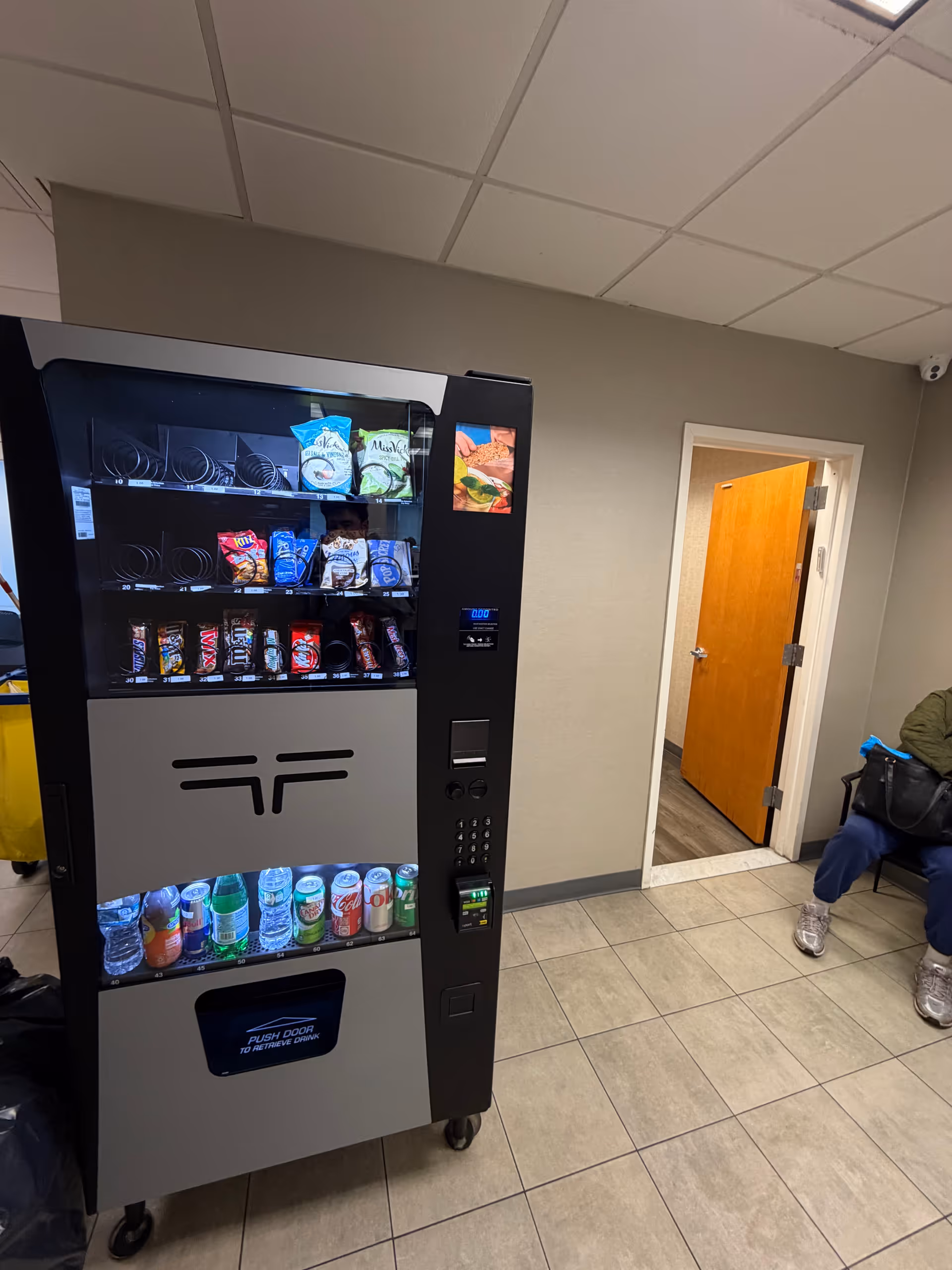Snack and drink vending machine in a hallway of a senior living facility.