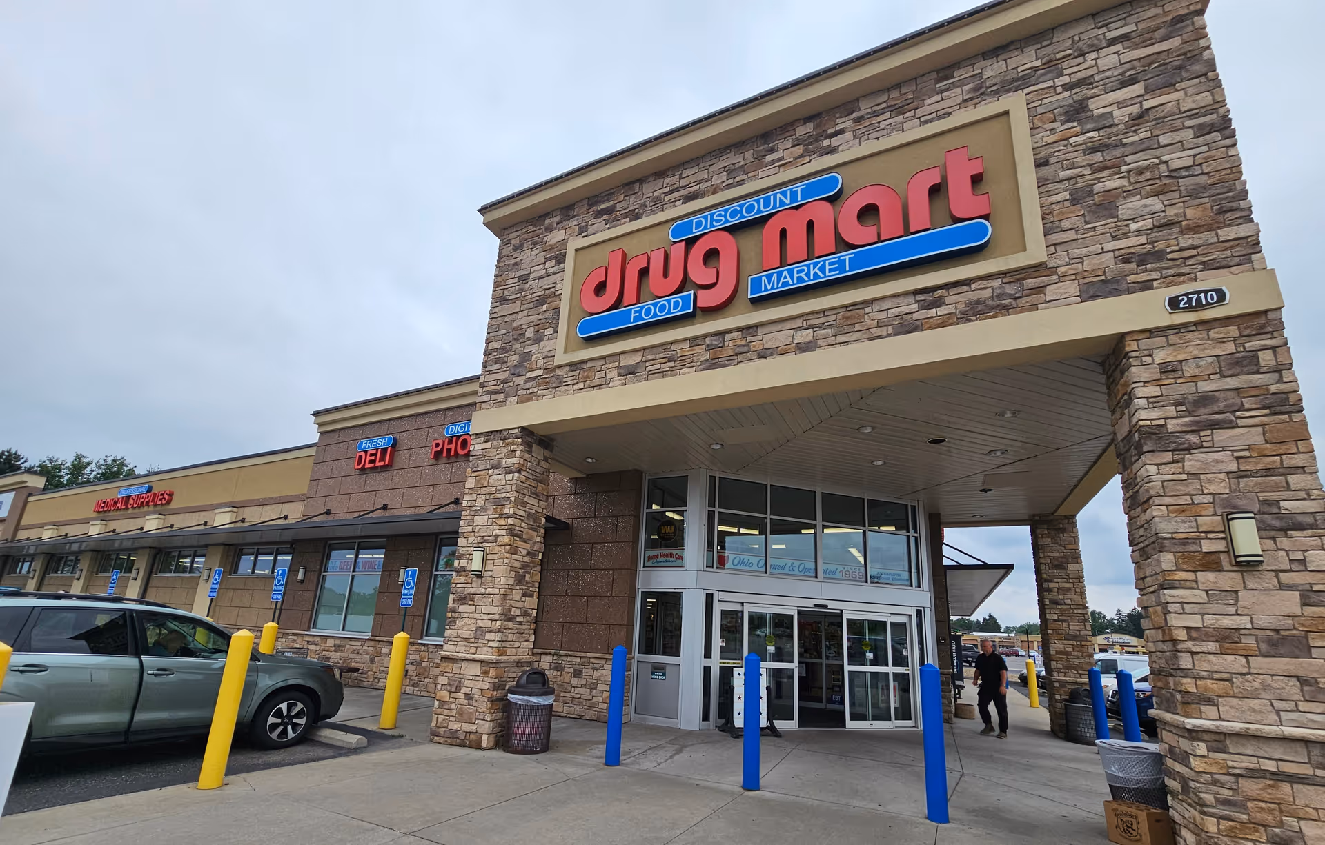 Exterior view of a Discount Drug Mart storefront with stone facade and entrance.