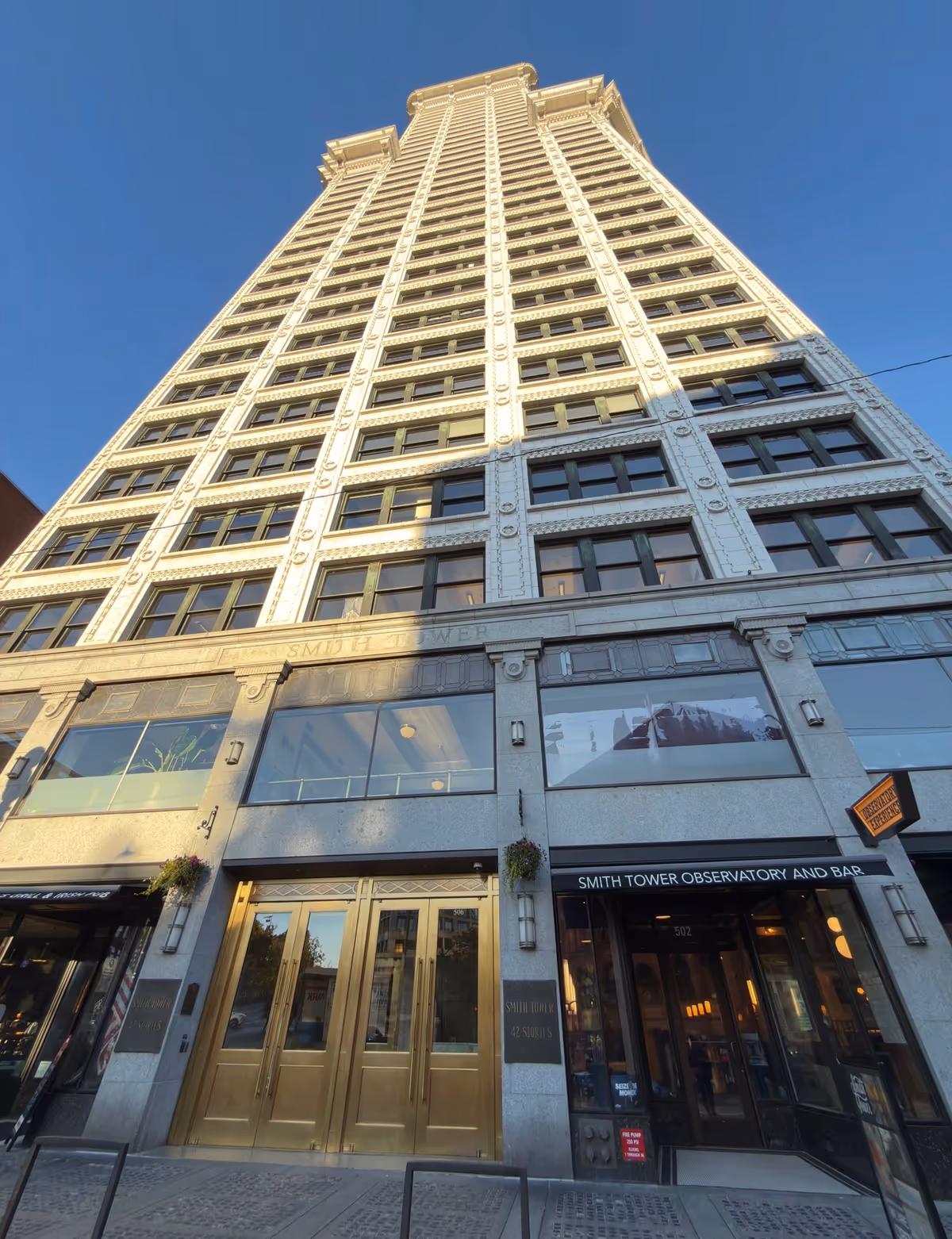 Tall ornate building exterior with gold doors and large windows.
