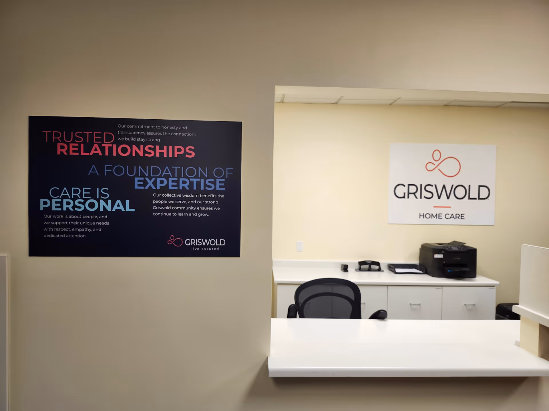 Reception area with desk, chair, and Griswold Home Care sign on the wall