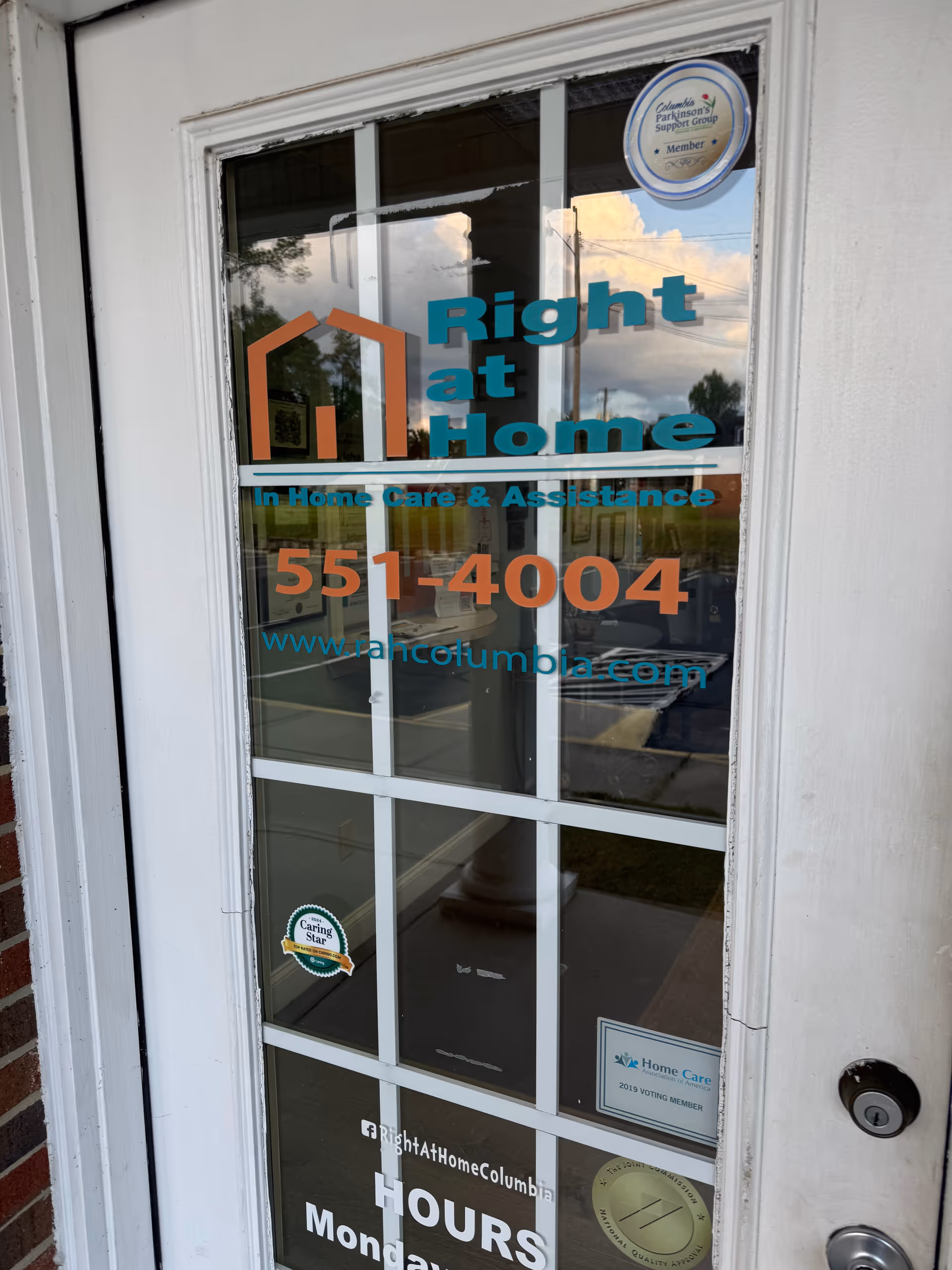 Glass door entry with Right at Home signage and contact number.