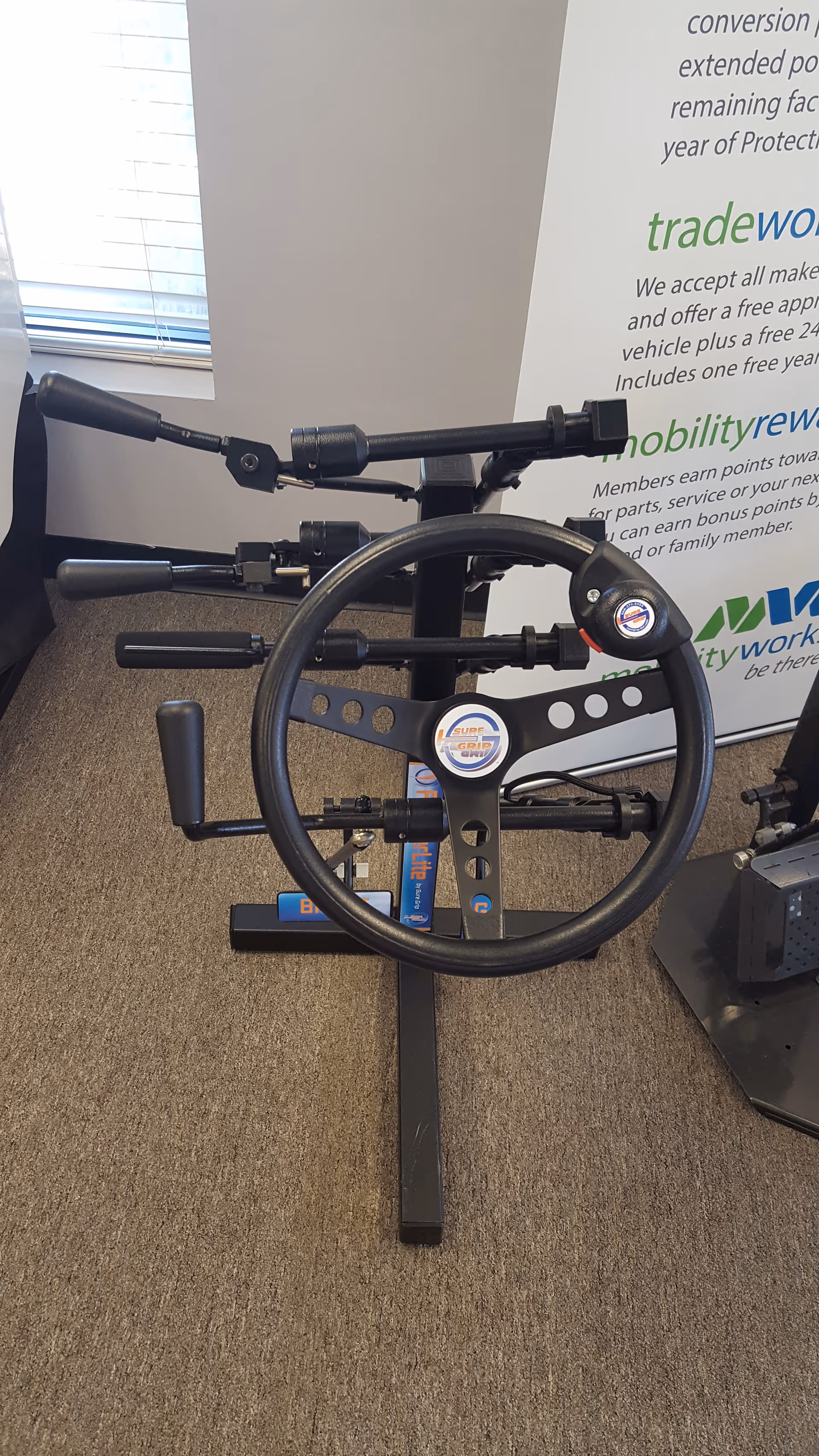 Indoor facility room with a stationary exercise bike and MobilityWorks banner.